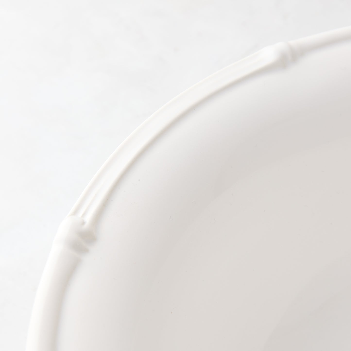 White ceramic dinner plate with a molded bamboo-style rim, 11" diameter.