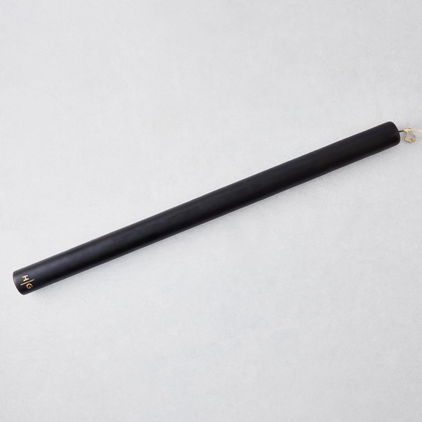 Oversized 22-inch black hand-dipped taper candle with a gold HG logo embossed on the base.