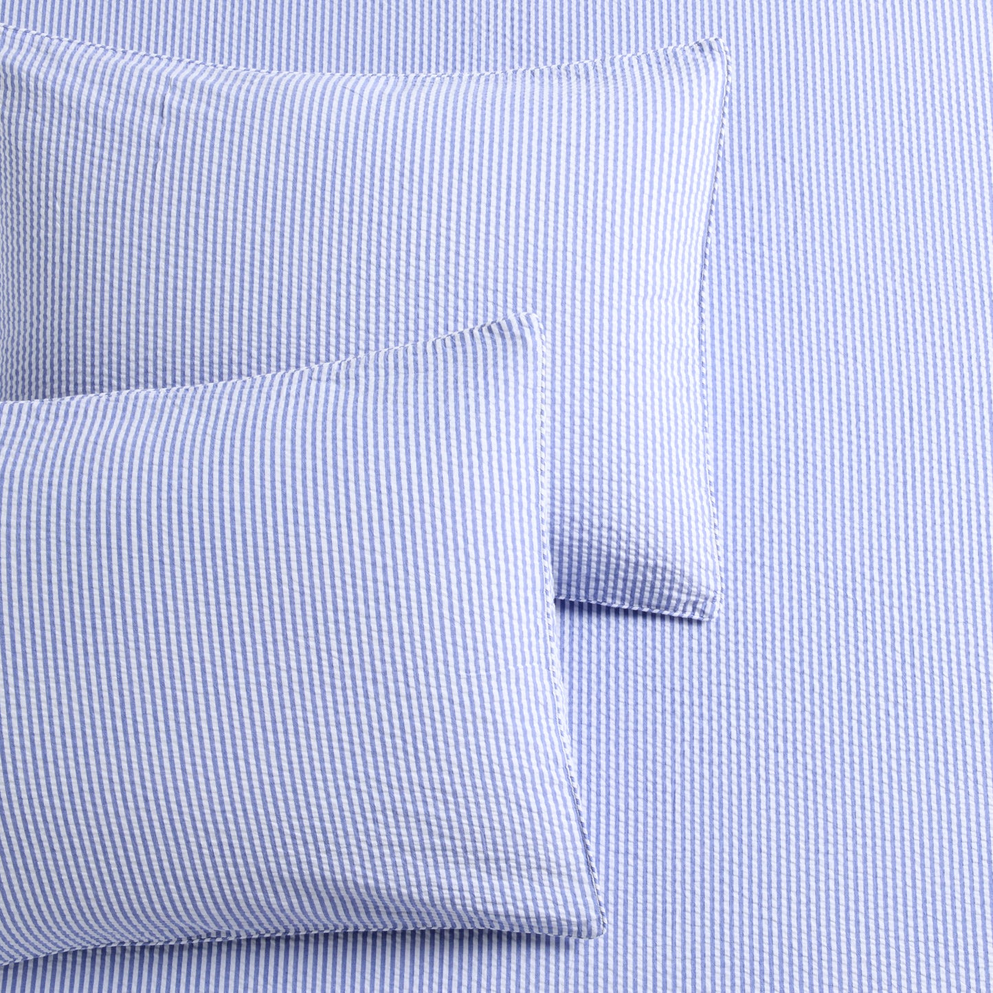 Blue seersucker stripe organic cotton duvet cover and two shams with button and envelope closures.