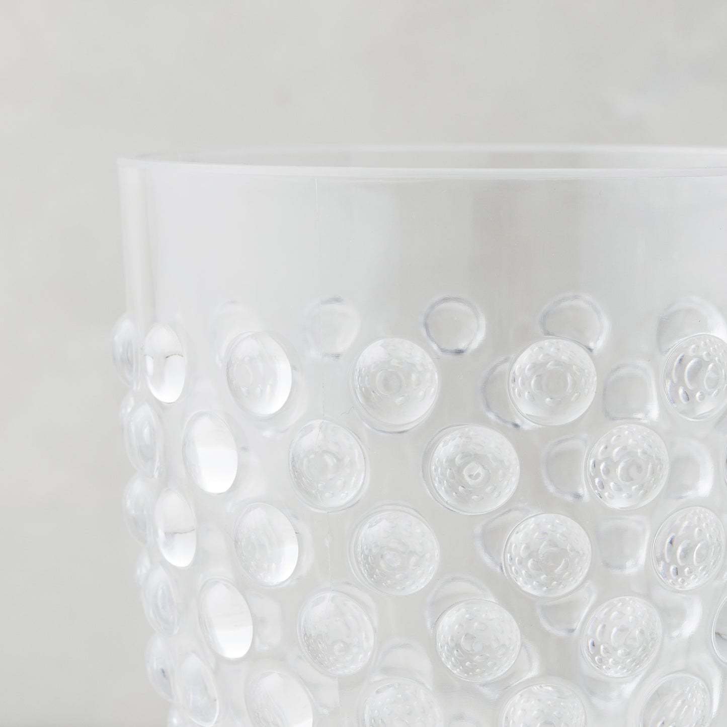Clear acrylic wine glass with a textured bubble design.