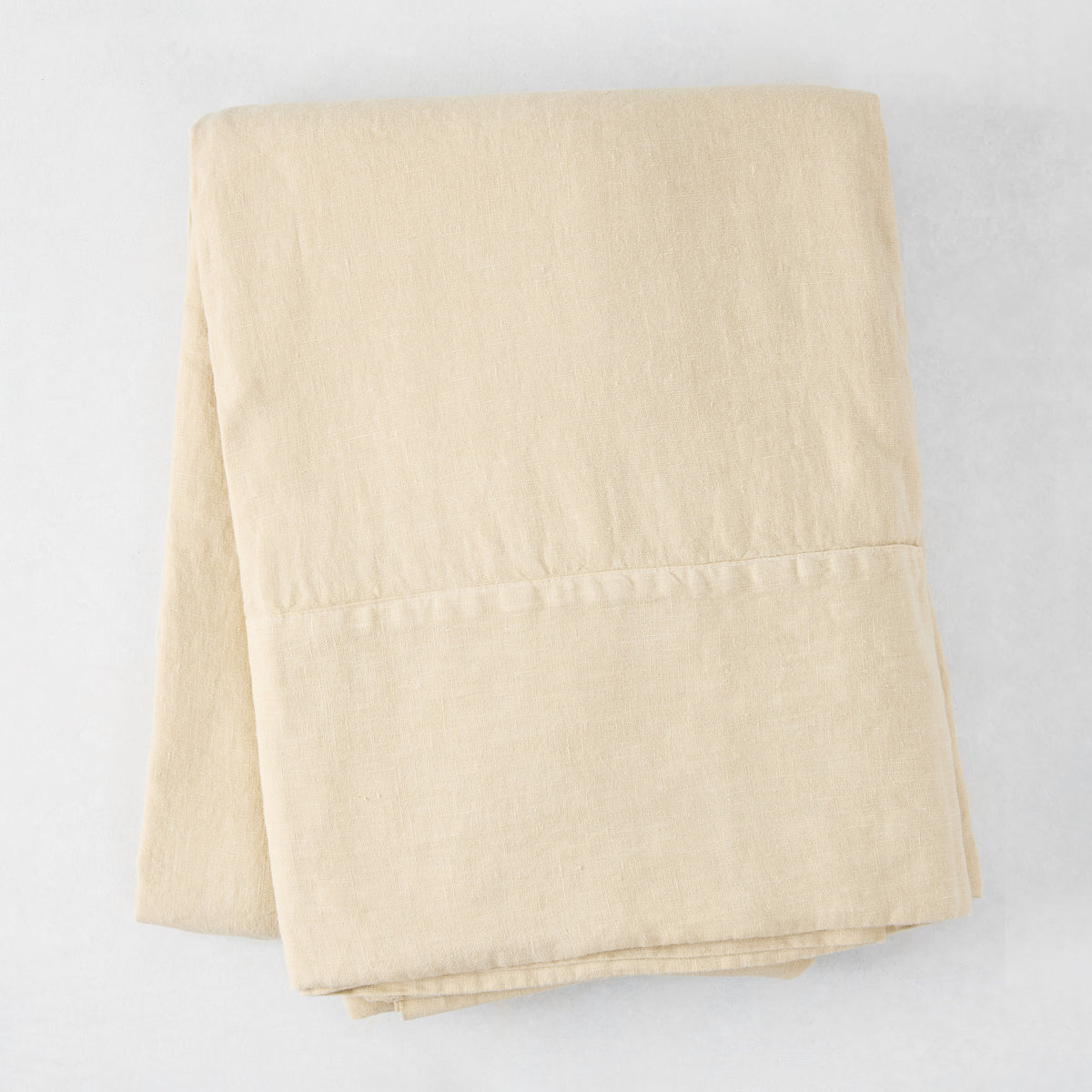 Folded Buttermilk HG Signature Hand-Dyed Linen Tablecloth, 70" x 126", soft khaki color.