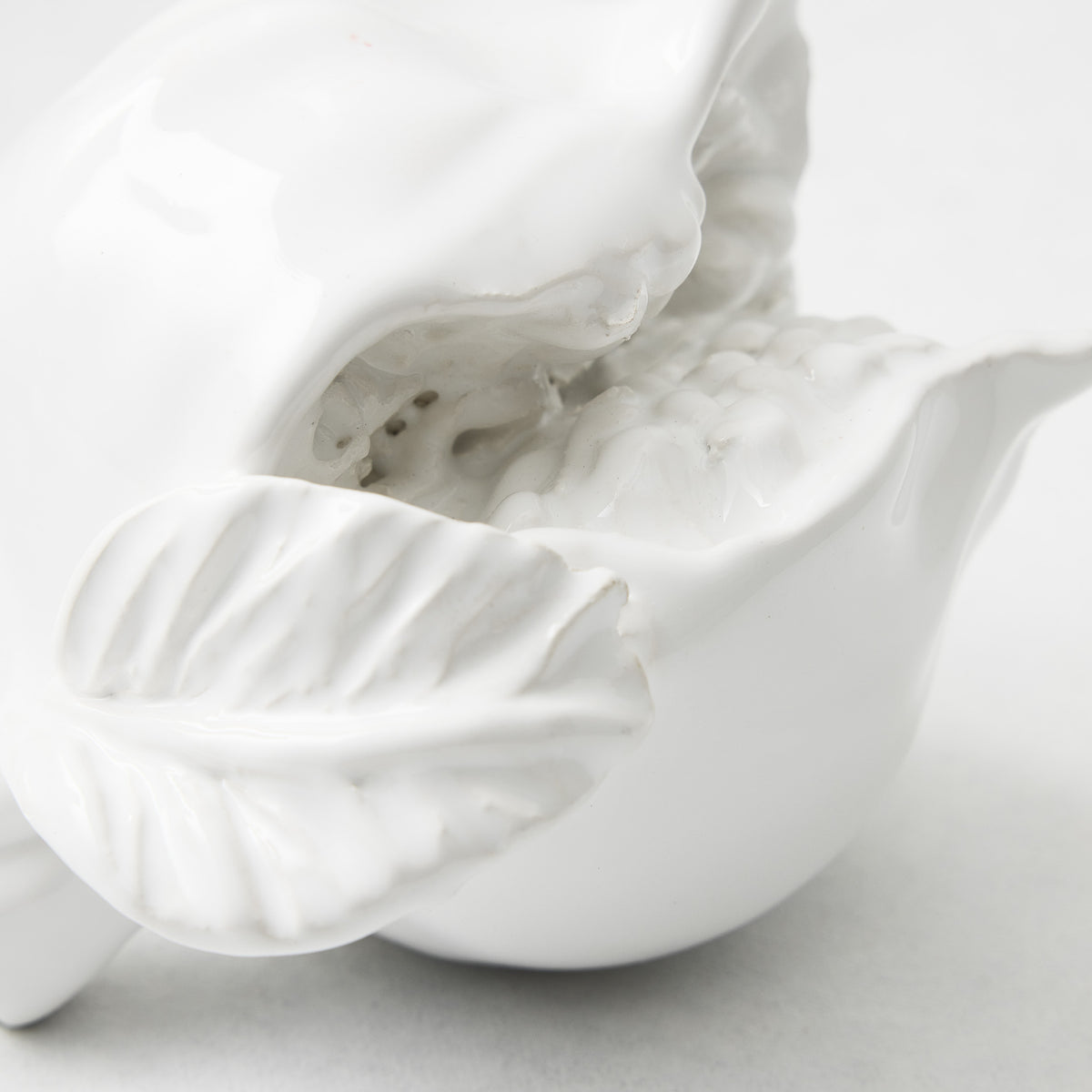 Handmade white ceramic pomegranate decorative piece with glossy glaze and detailed leaf texture.