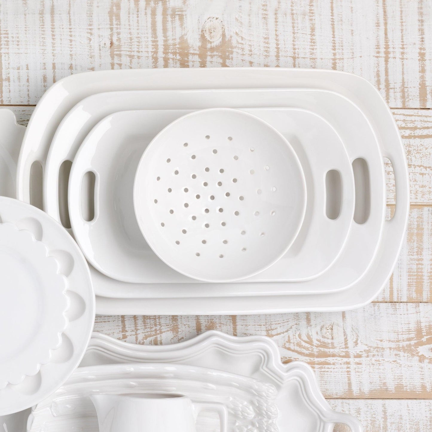White ceramic serving platter with elegant handles, high-fired earthenware, and thick glaze.