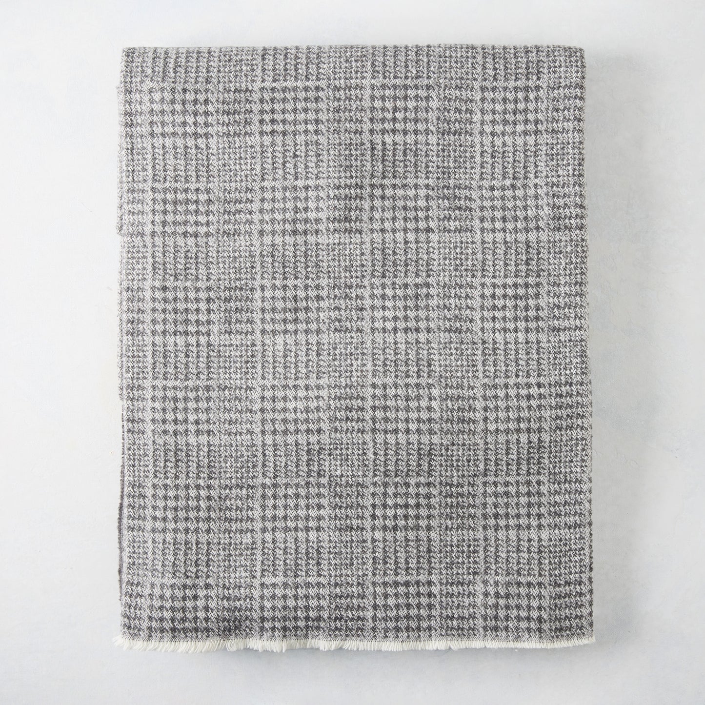 Charcoal grey Sutton Houndstooth throw blanket, 51"W x 67"L, cotton-acrylic blend with raw edge.