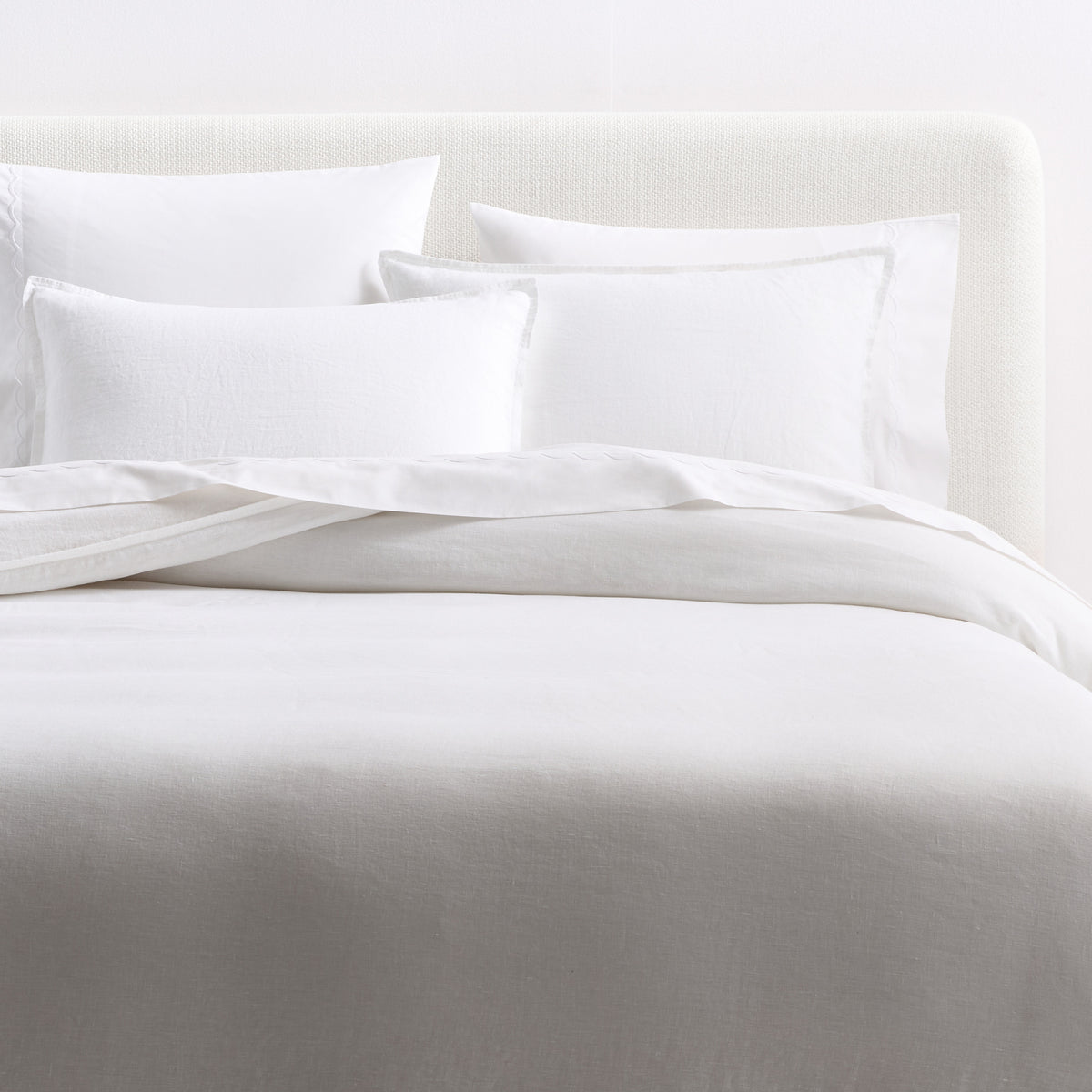 Cloud white European washed linen duvet cover and matching shams with a relaxed, soft texture on a bed.