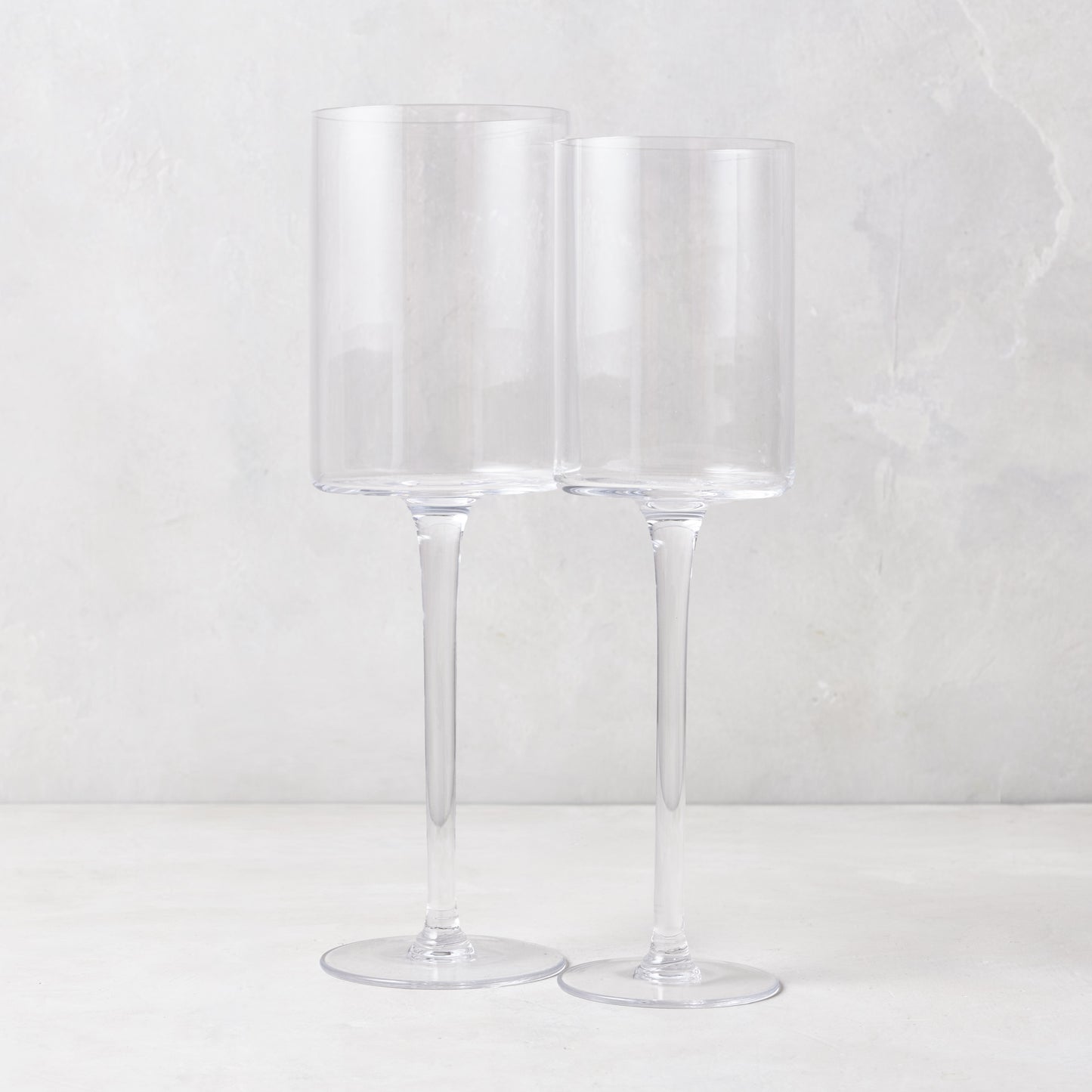 Two clear, tall Diane Keaton + Hudson Grace High Rise wine glasses, one large and one smaller.