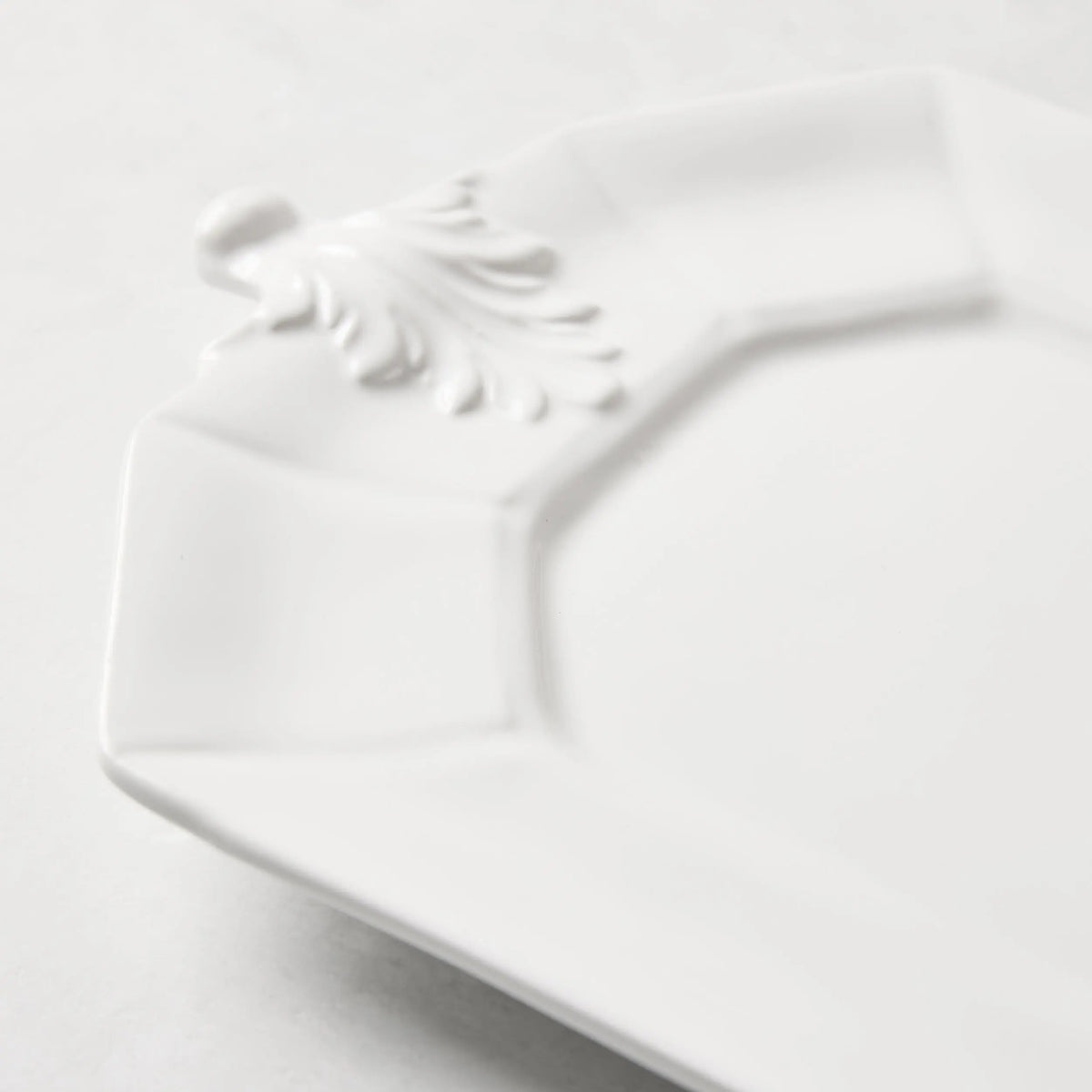 White octagon ceramic serving platter with raised Fleur de Lys detail.