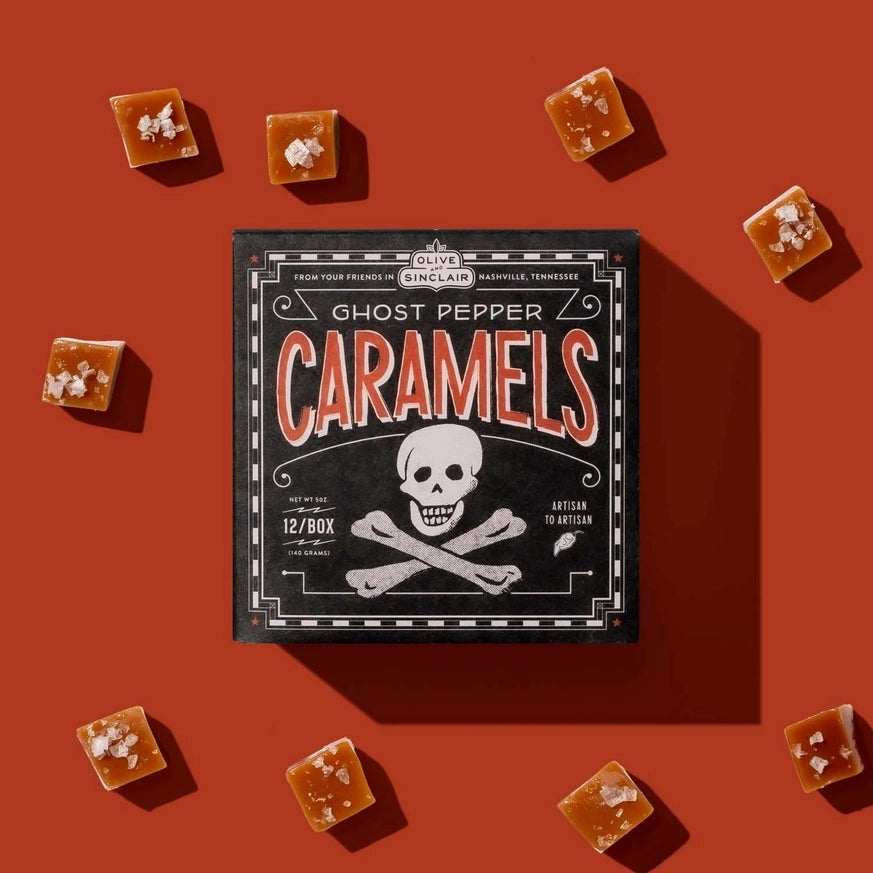 Hudson Grace Ghost Pepper Caramels box with skull graphic surrounded by individual salted caramel squares on red