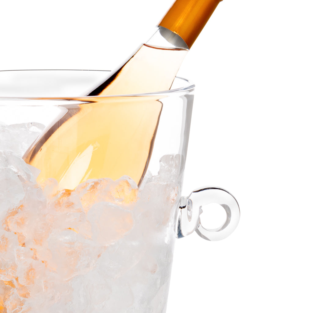 Handblown glass ice bucket with ring handles, filled with ice and a chilled bottle.
