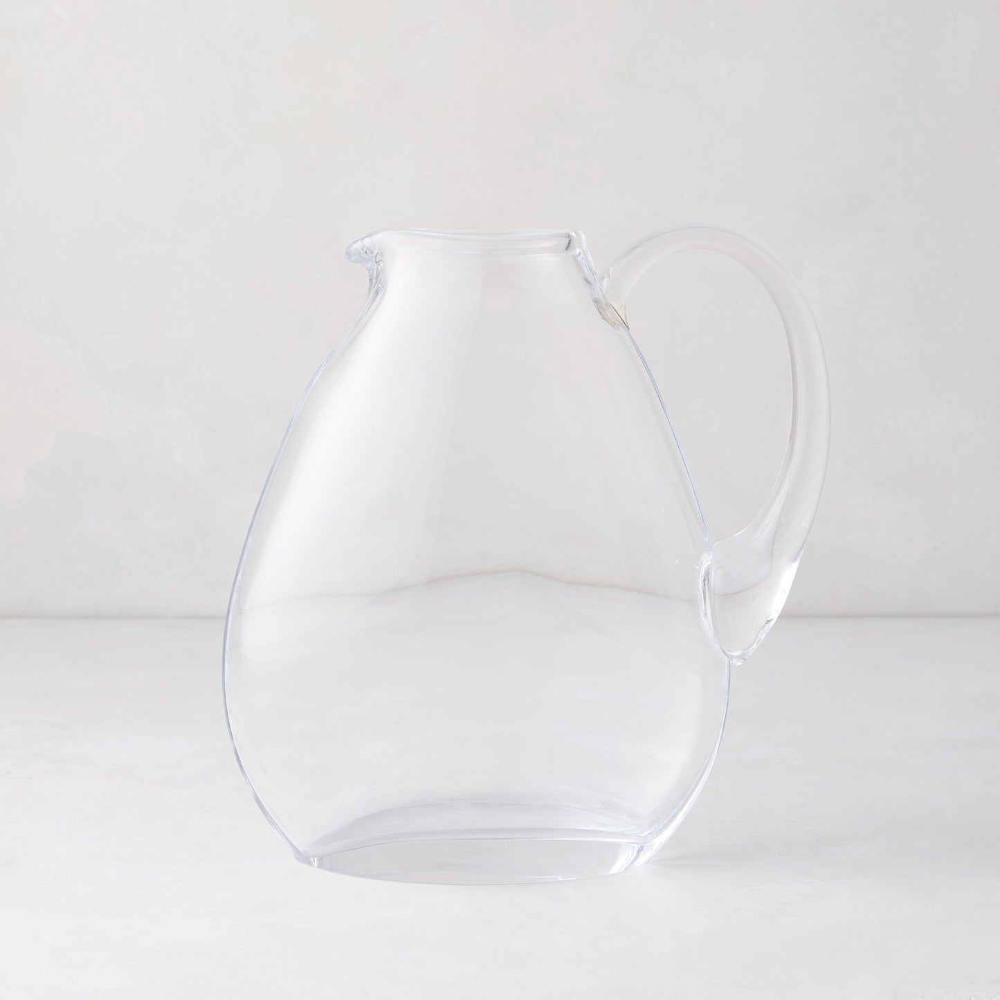 Clear mouth-blown glass teardrop pitcher with handle, 84.5oz, on a light background.
