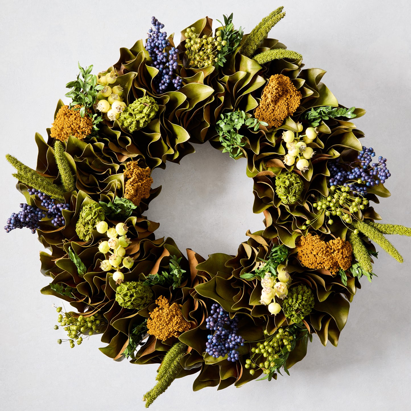 Golden Dawn Wreath with magnolia leaves, blue juniper, canella berries, rosehips, and golden yarrow.