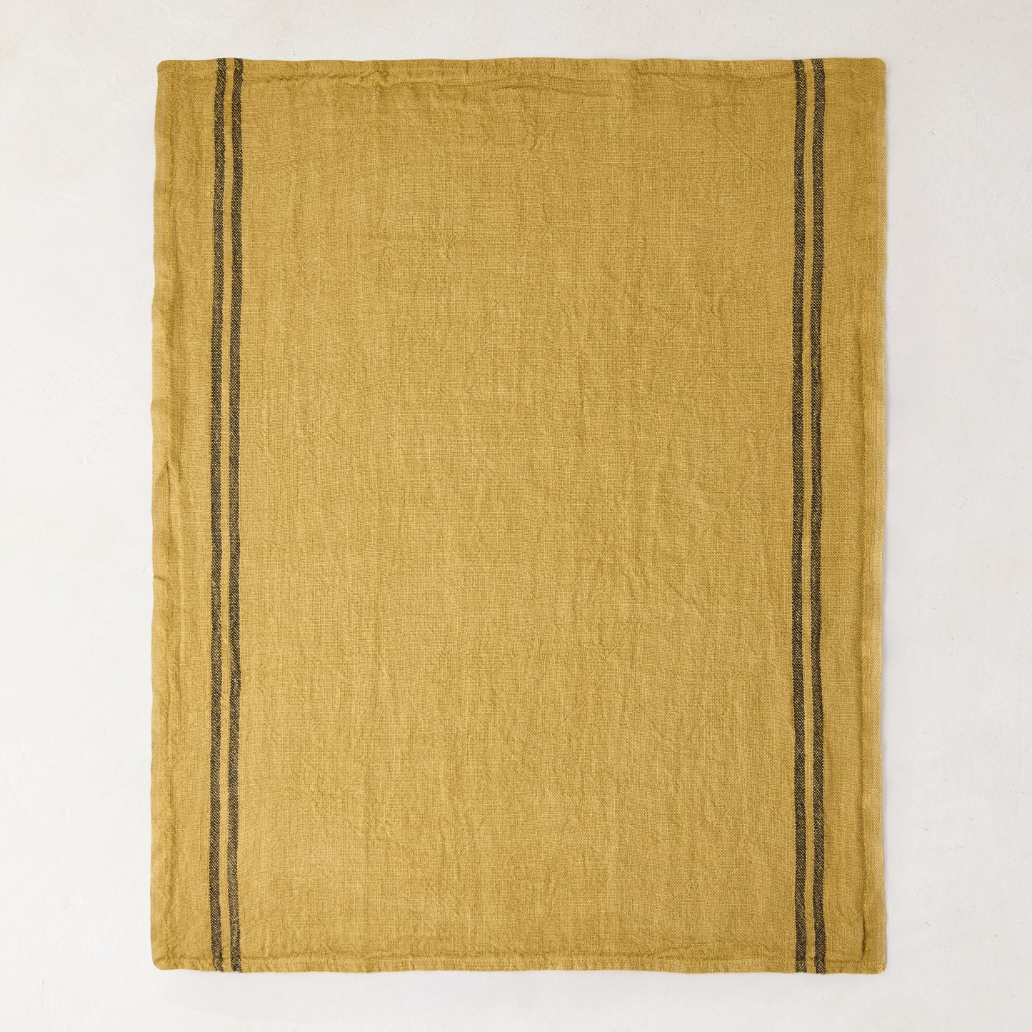Goldenrod yellow French linen tea towel with two vertical dark gray stripes on each side.
