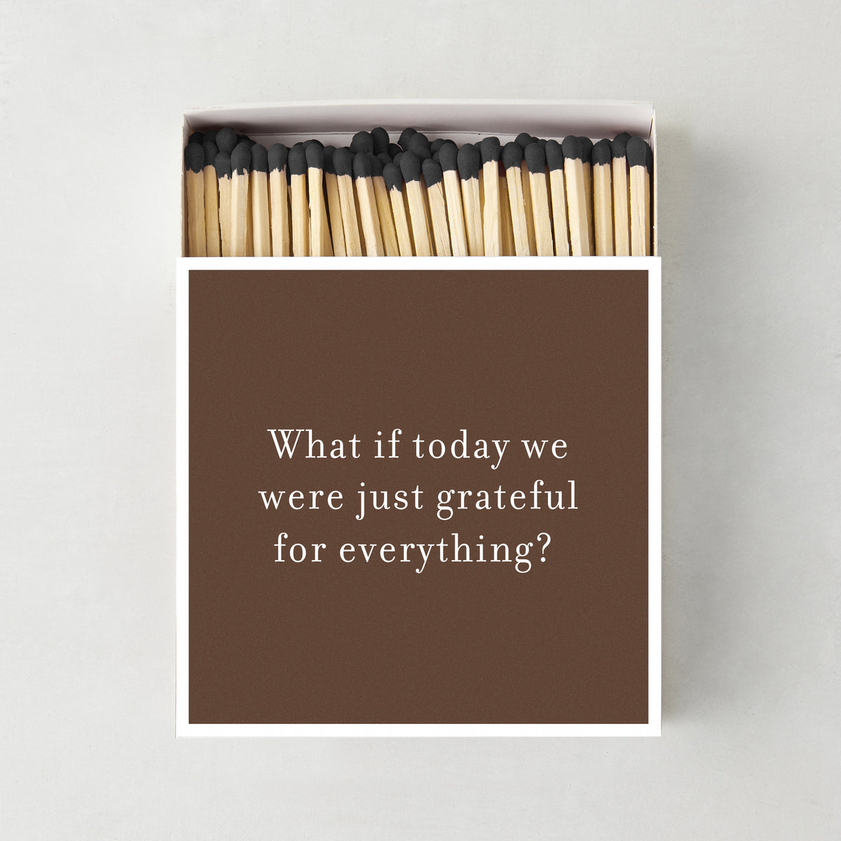 Oversized matchbox in brown with white text reading Grateful for Everything, containing 4-inch matches with black tips.