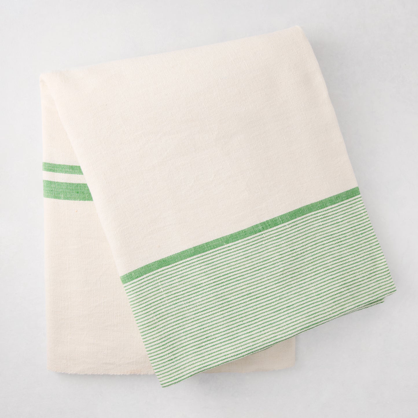 Folded Green Boat Stripe Tablecloth, 70"x108" cotton-linen blend, with green striped border.