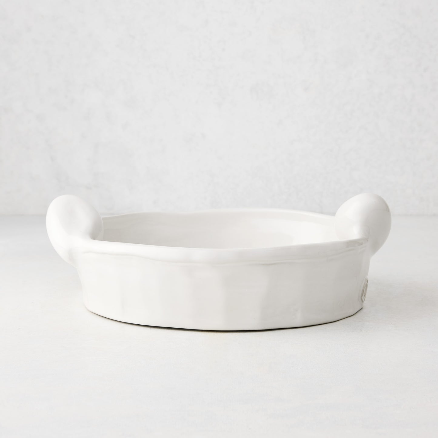 Handmade Montes Doggett ceramic round baker, creamy white glaze, 9"Dia x 2.5"H, with small handles.