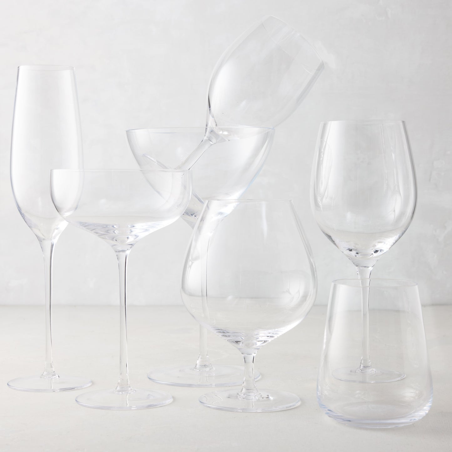 Clear mouth-blown HG Heritage Cognac Glass with a generous bowl, alongside other clear drinkware.