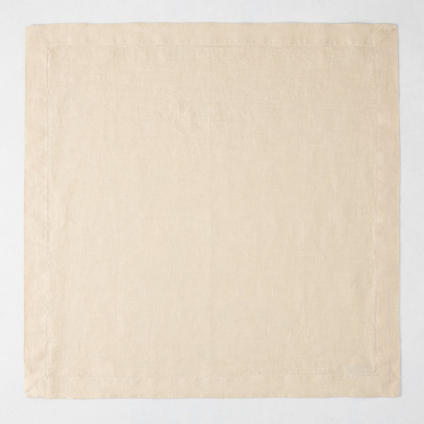 HG Buttermilk Hand-Dyed Linen Napkin, 22" square, light beige with mitered corners.
