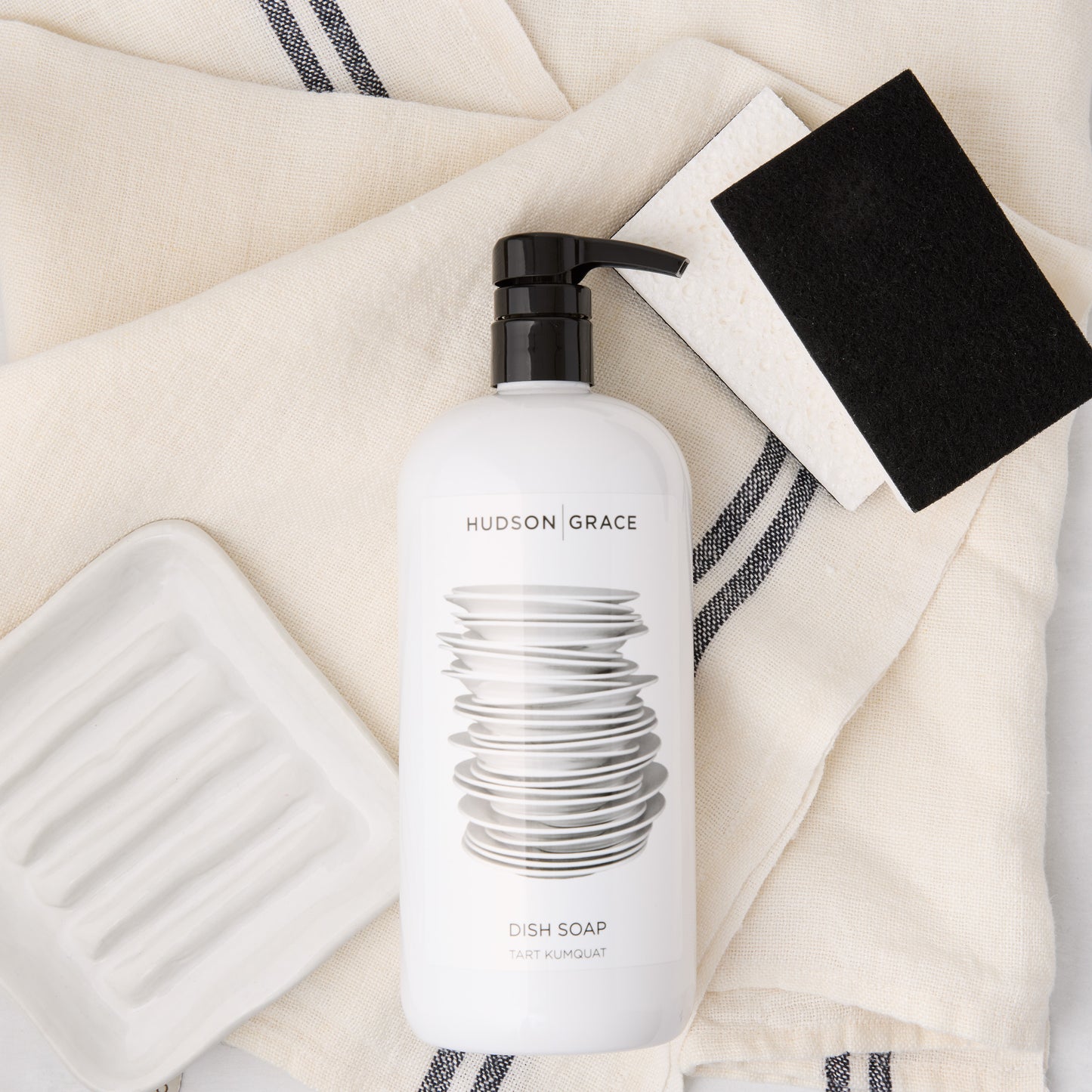 HG Cleaning Bundle: white dish soap, ceramic soap dish, striped linen towel, black and white sponges.