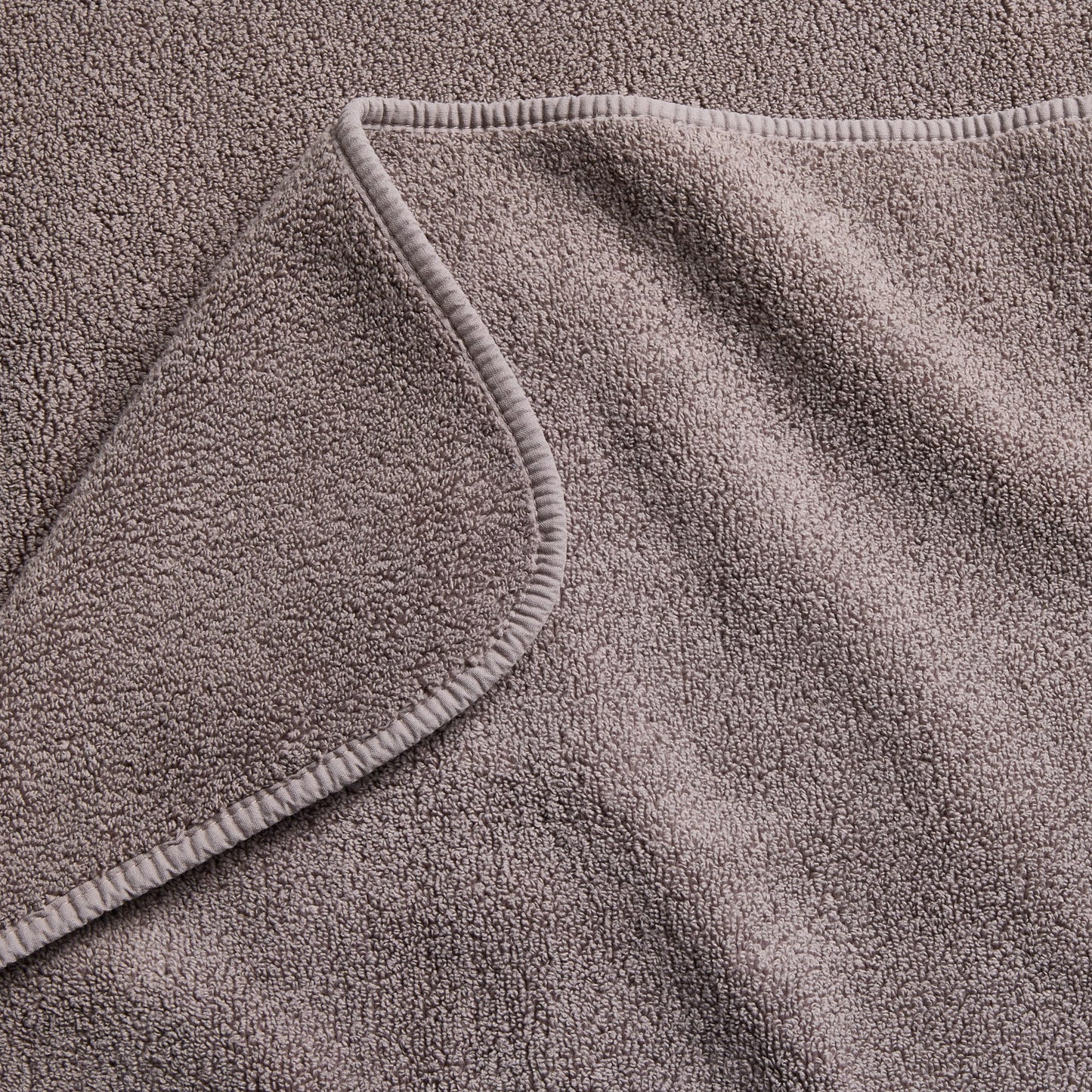 Stone gray Signature bath sheet featuring a soft, absorbent cotton terry texture and a finished stitched hem.