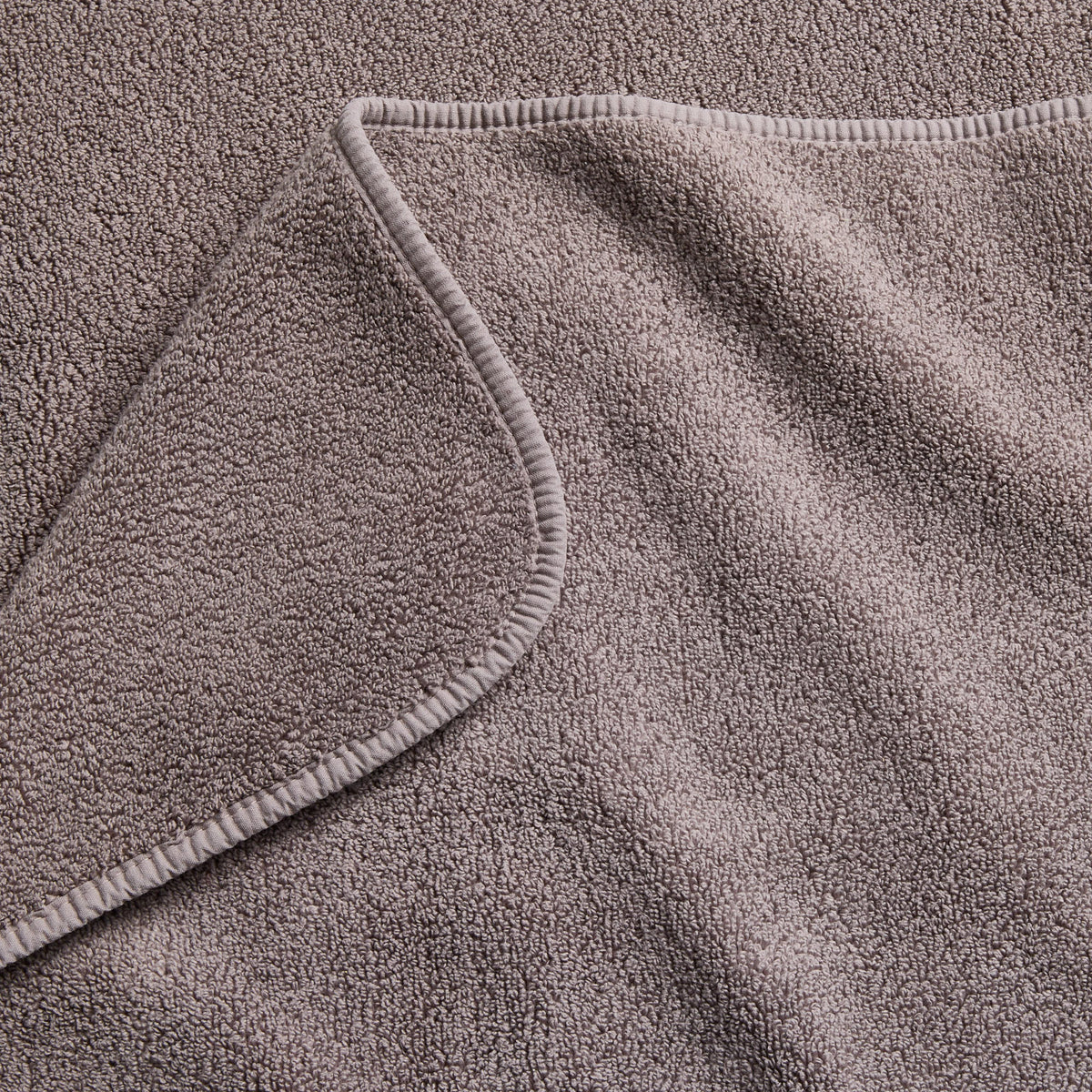 Stone gray Signature bath sheet featuring a soft, absorbent cotton terry texture and a finished stitched hem.