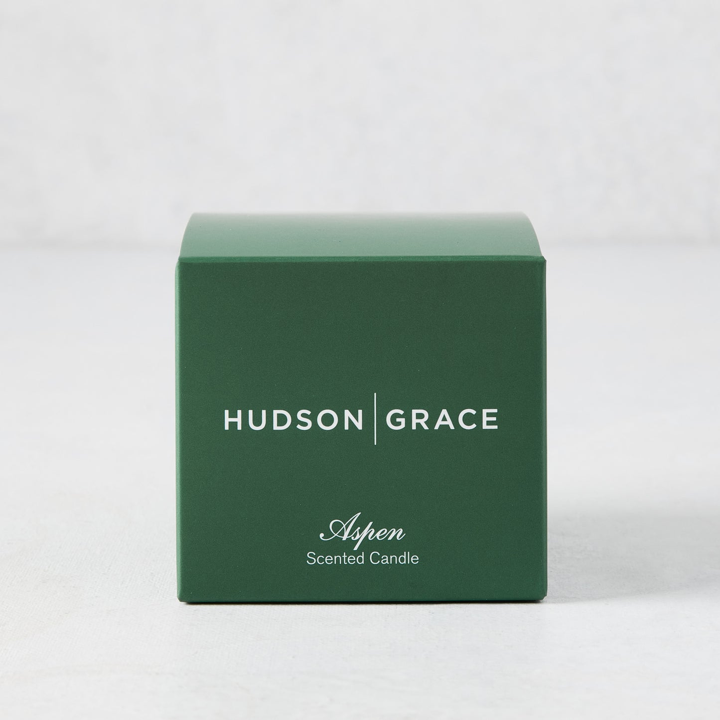 Hudson Grace Aspen Scented Votive candle in a dark green box with white text.