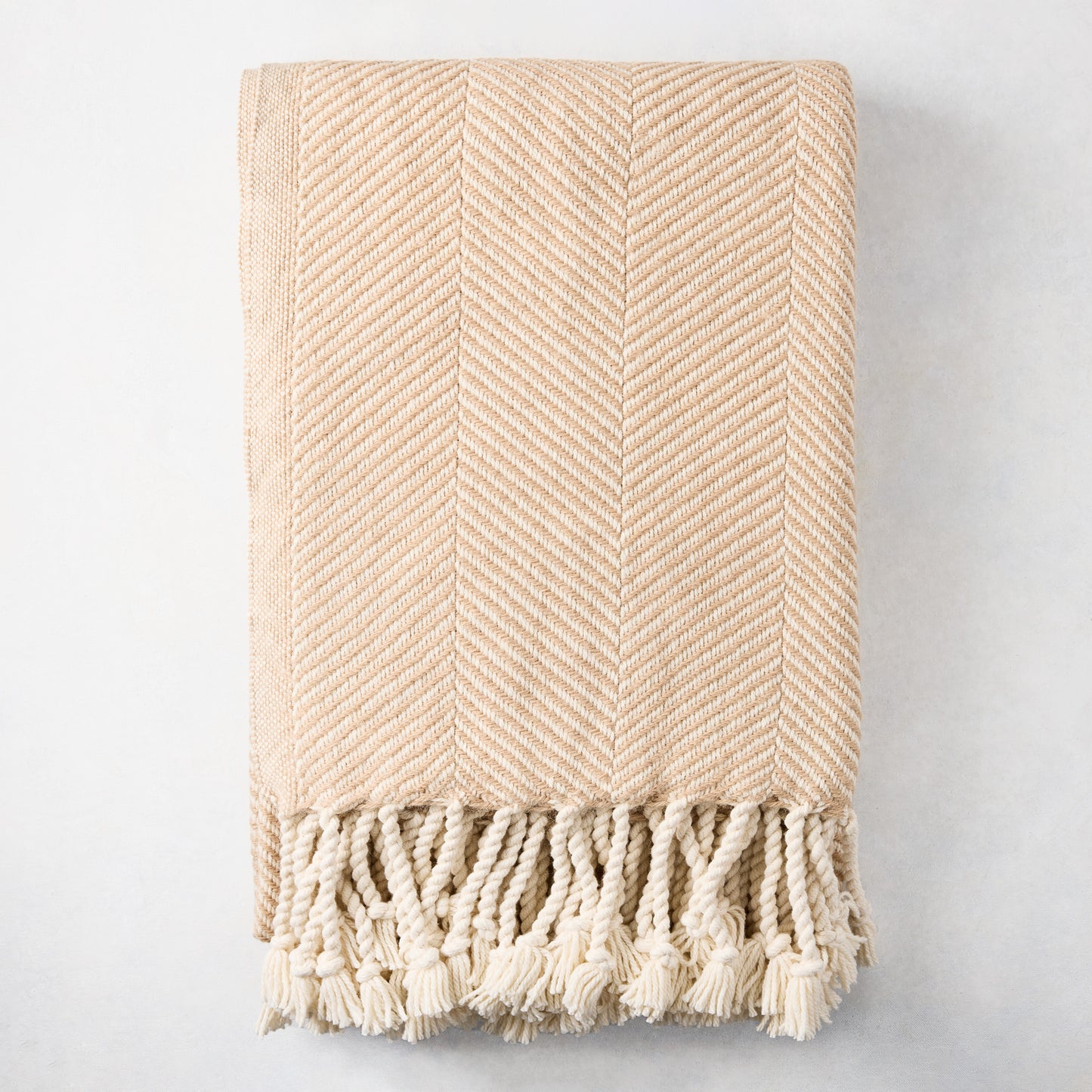 Khaki chevron cotton throw blanket with thick rope fringe.