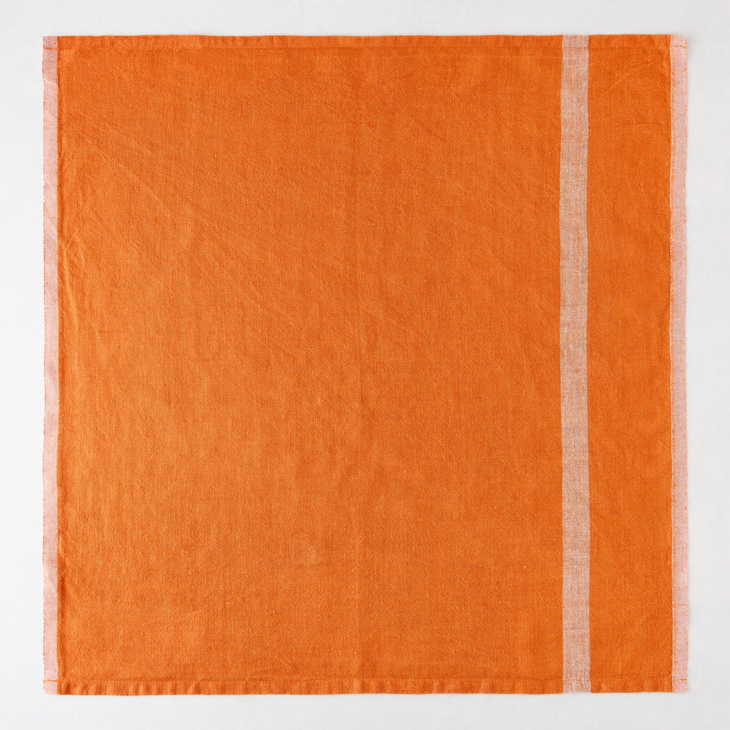 Bright orange laundered linen napkin with paler vertical stripes.