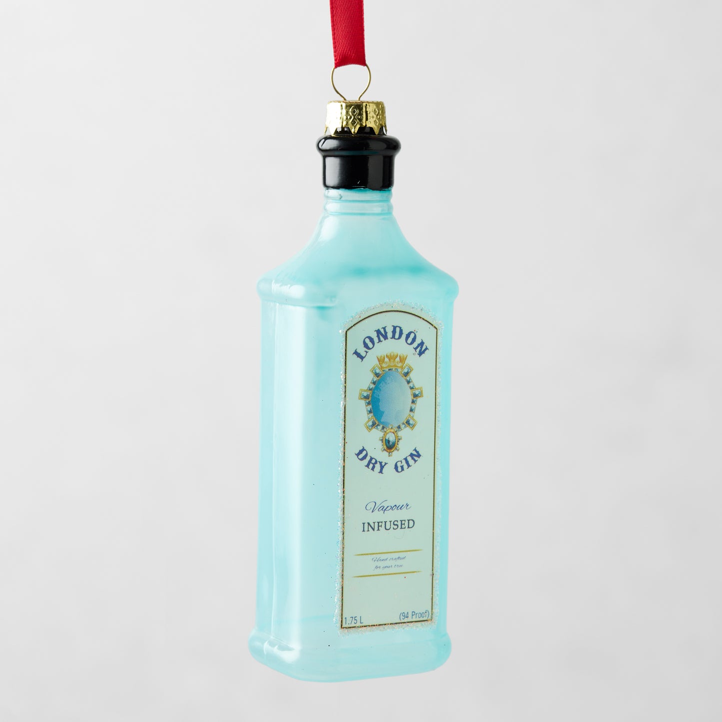 Light blue London Dry Gin bottle Christmas ornament, 5"H glass with gold and black accents, red ribbon.