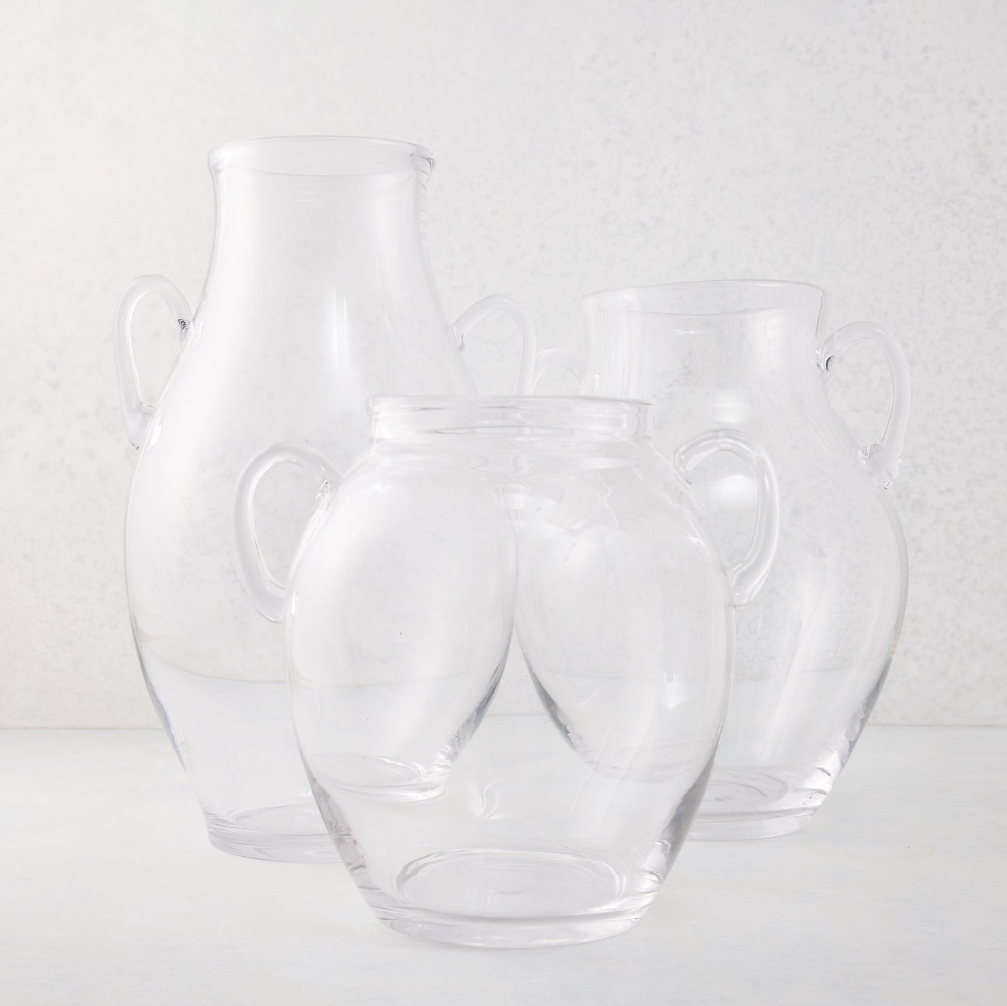 Medium recycled clear glass confit vase with organic curves and decorative handles.
