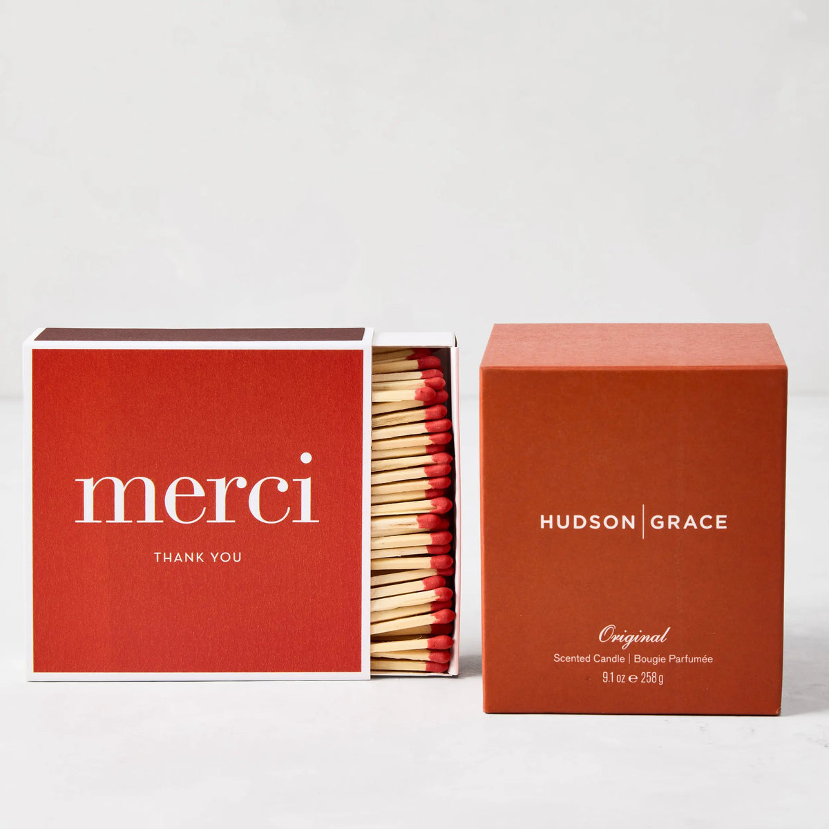 Red "merci" boxed matches with long wooden sticks and a matching Hudson Grace candle.