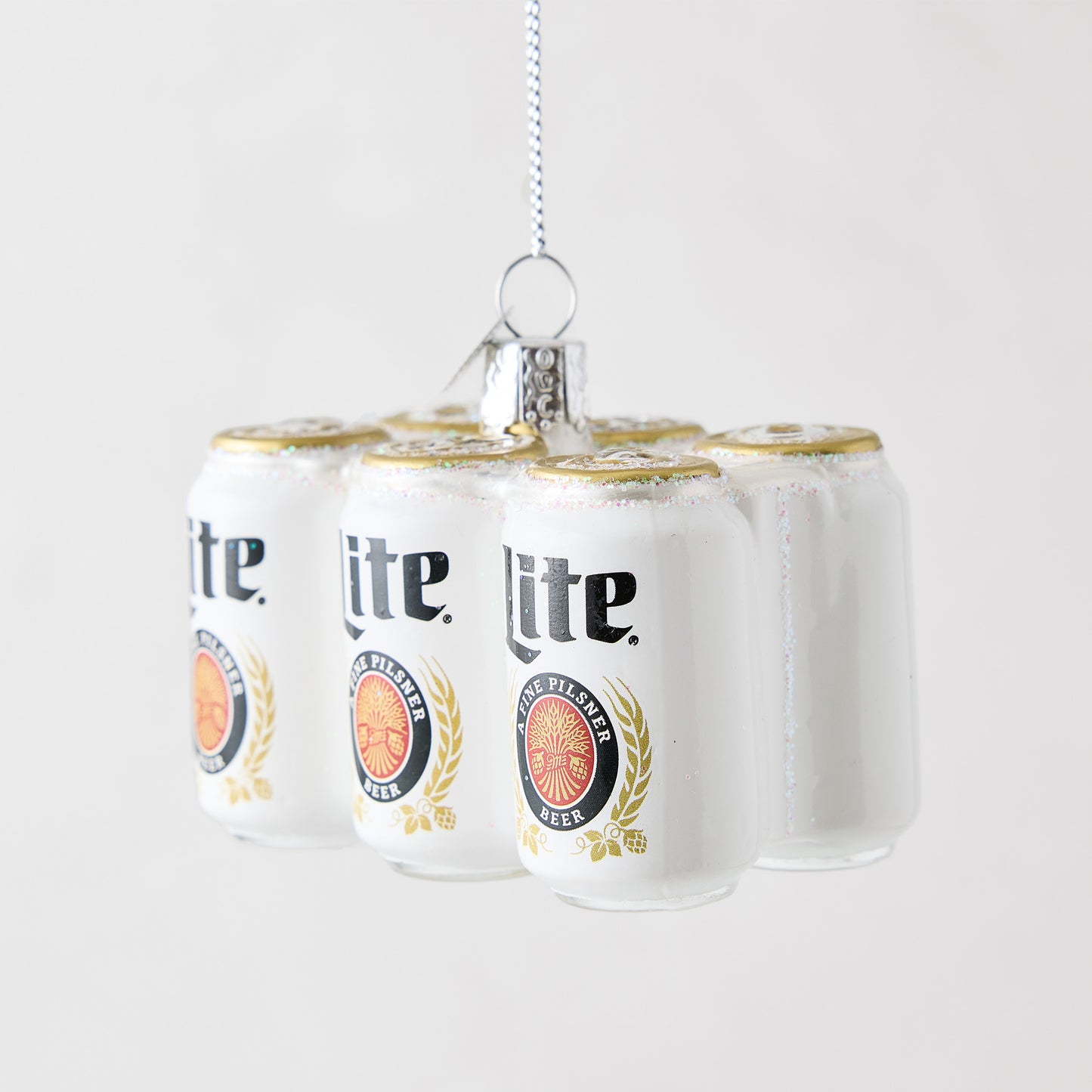 Hand-painted glass Miller Lite six-pack beer can ornament with glitter accents and a silver hanging loop.
