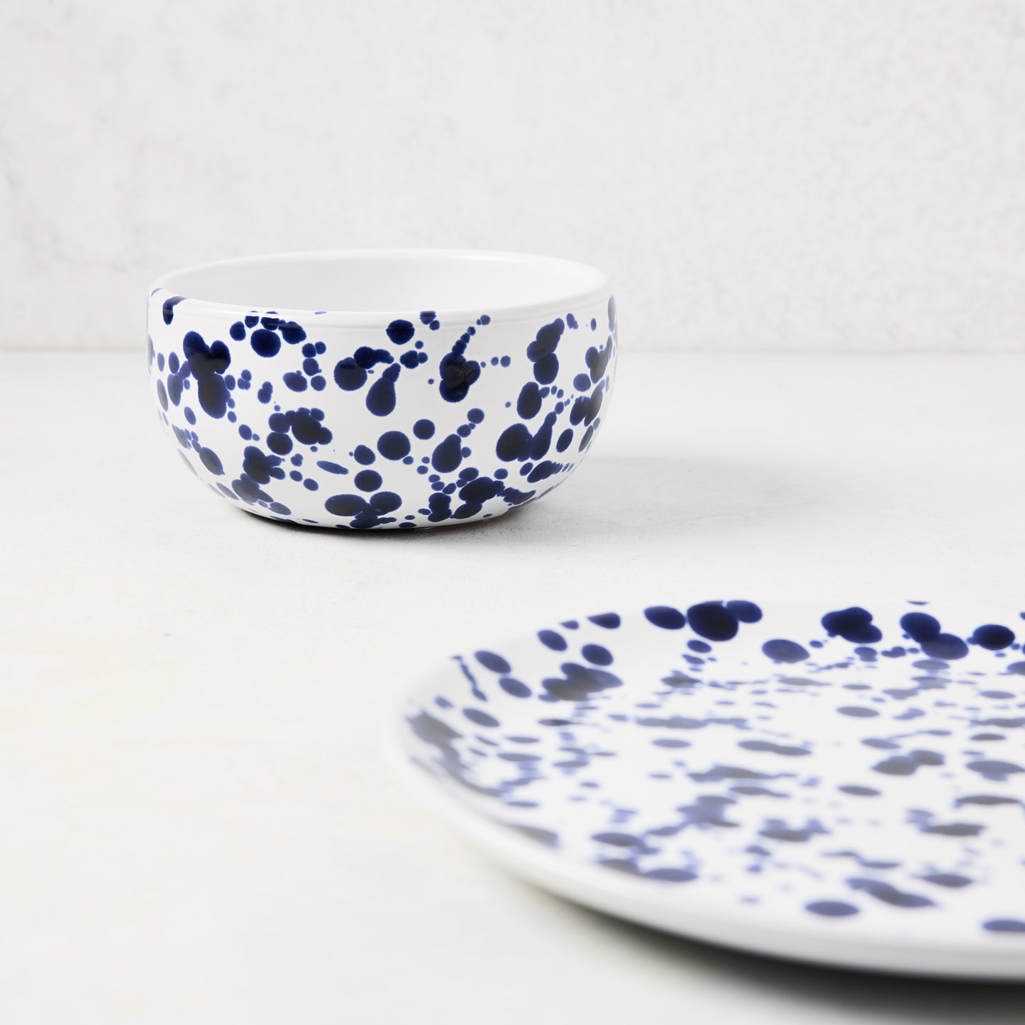 Navy blue splatter stoneware salad plate and matching bowl.