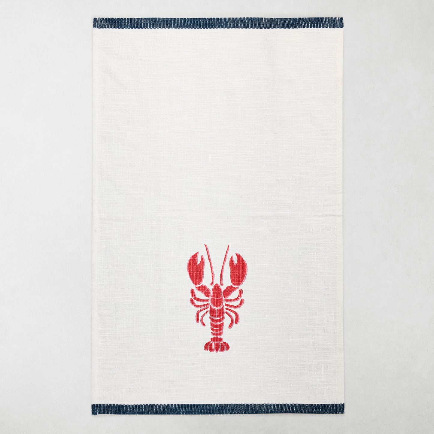 White cotton hand towel with a red lobster print and navy top and bottom borders.