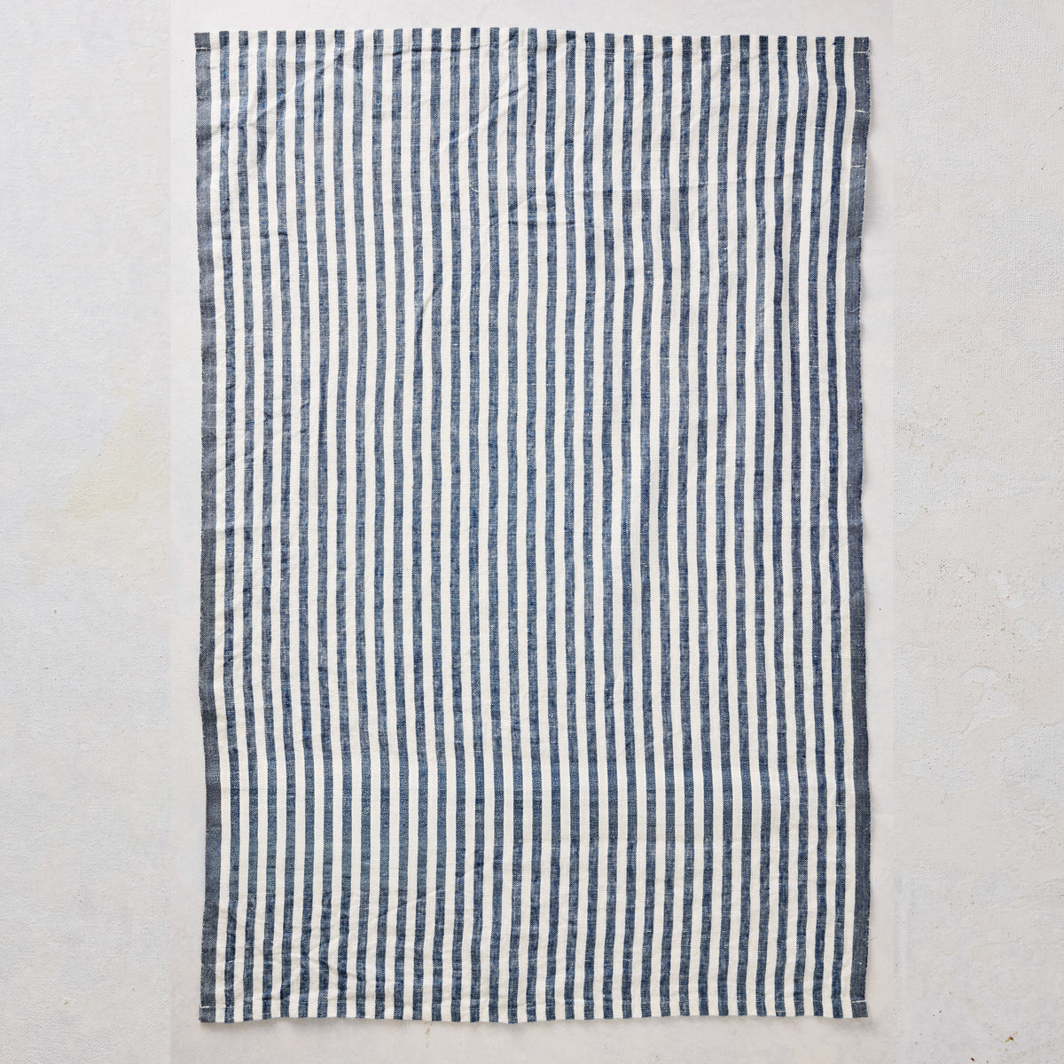 Set of two 30x20 inch navy blue and white ticking stripe linen hand towels with yellow border detail.