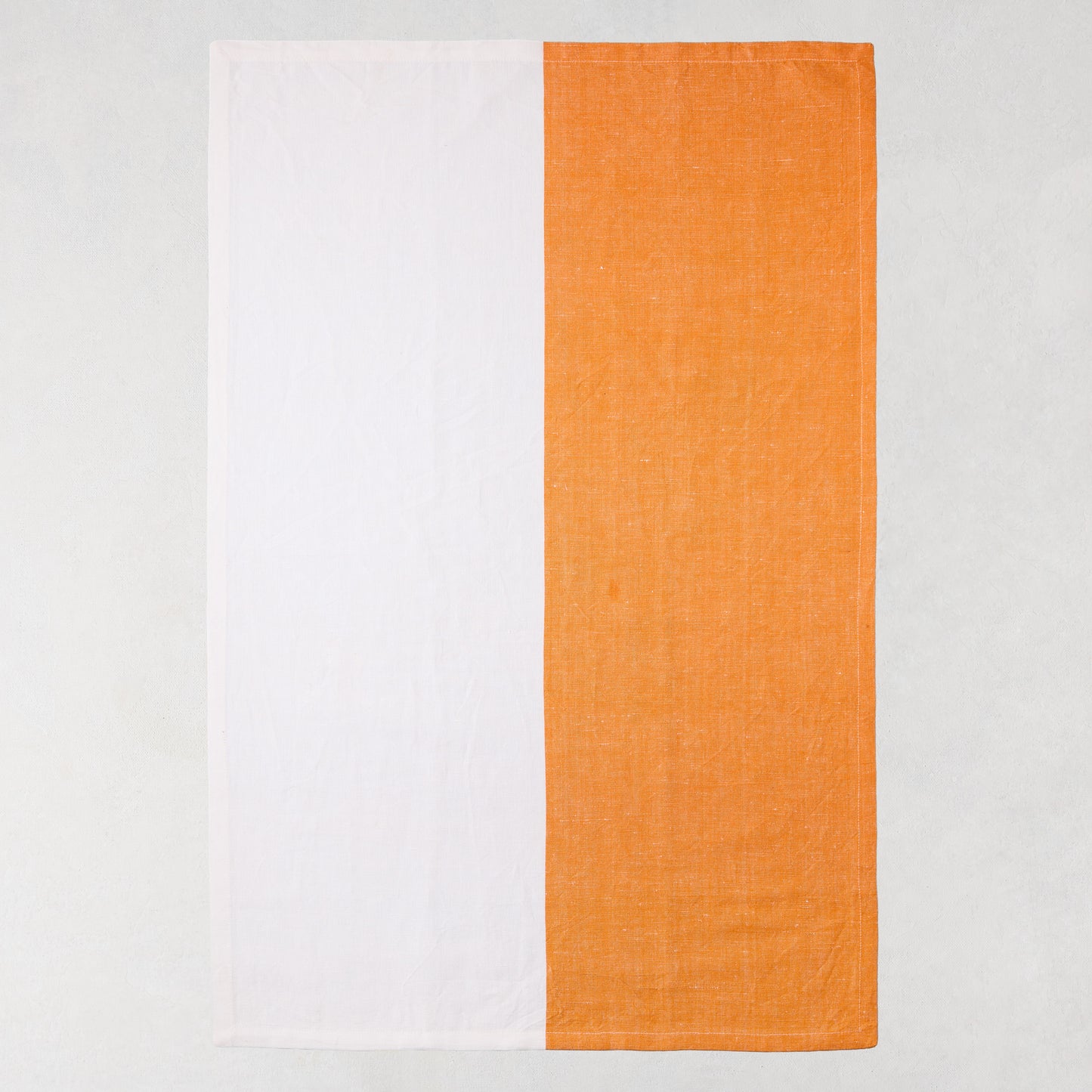 Orange and white block print cotton-linen hand towel, half orange, half white.