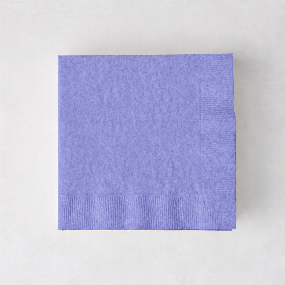 Square lavender purple 3-ply paper cocktail napkin with a textured border on a light background.