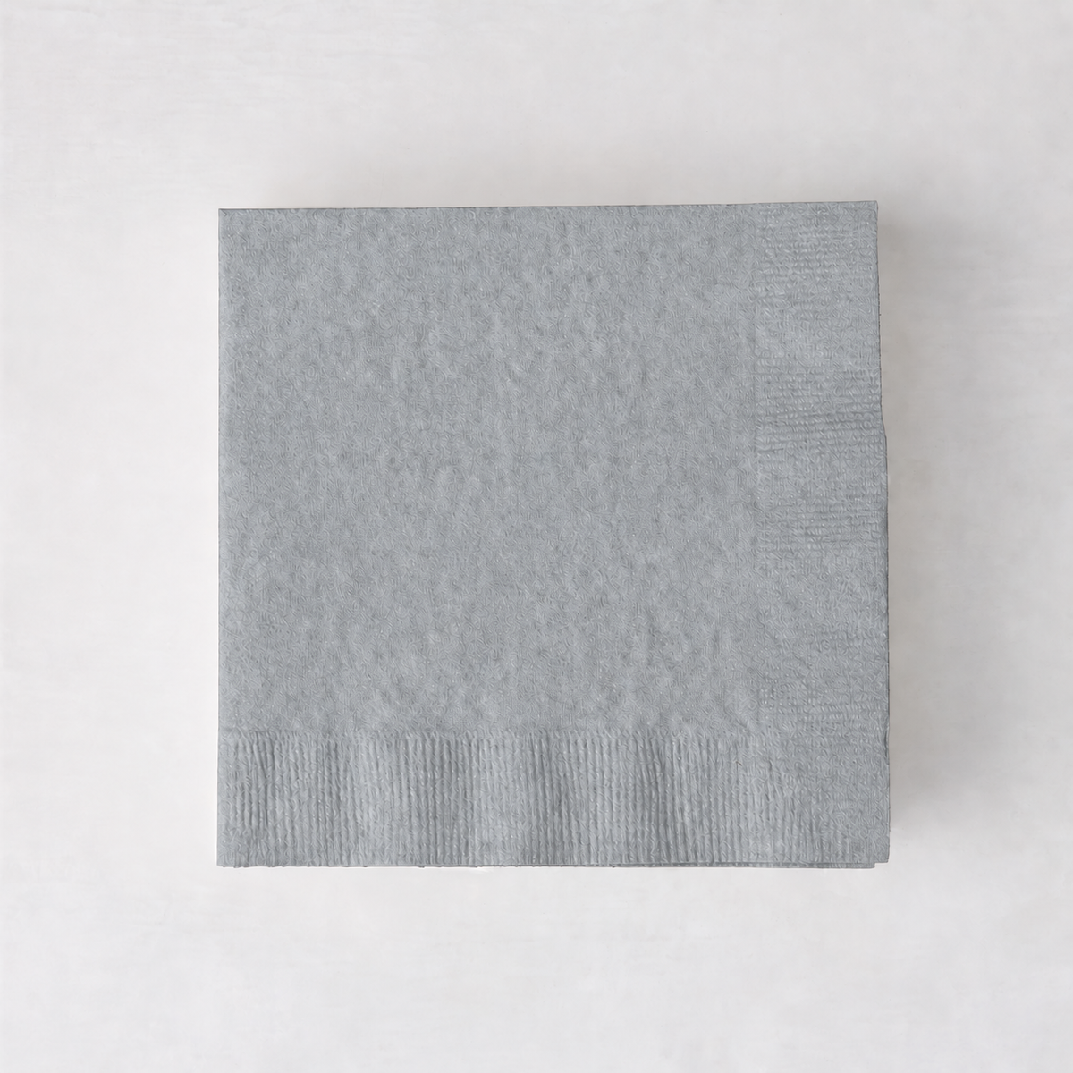 Square silver 3-ply paper cocktail napkin with embossed border detail on a white background.