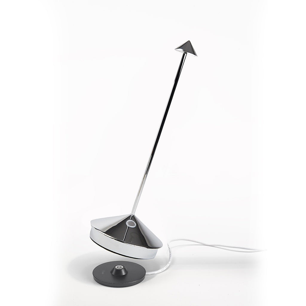 Pina Pro glossy chrome rechargeable LED lamp with broad base, thin rod, and small shade, next to charging base.