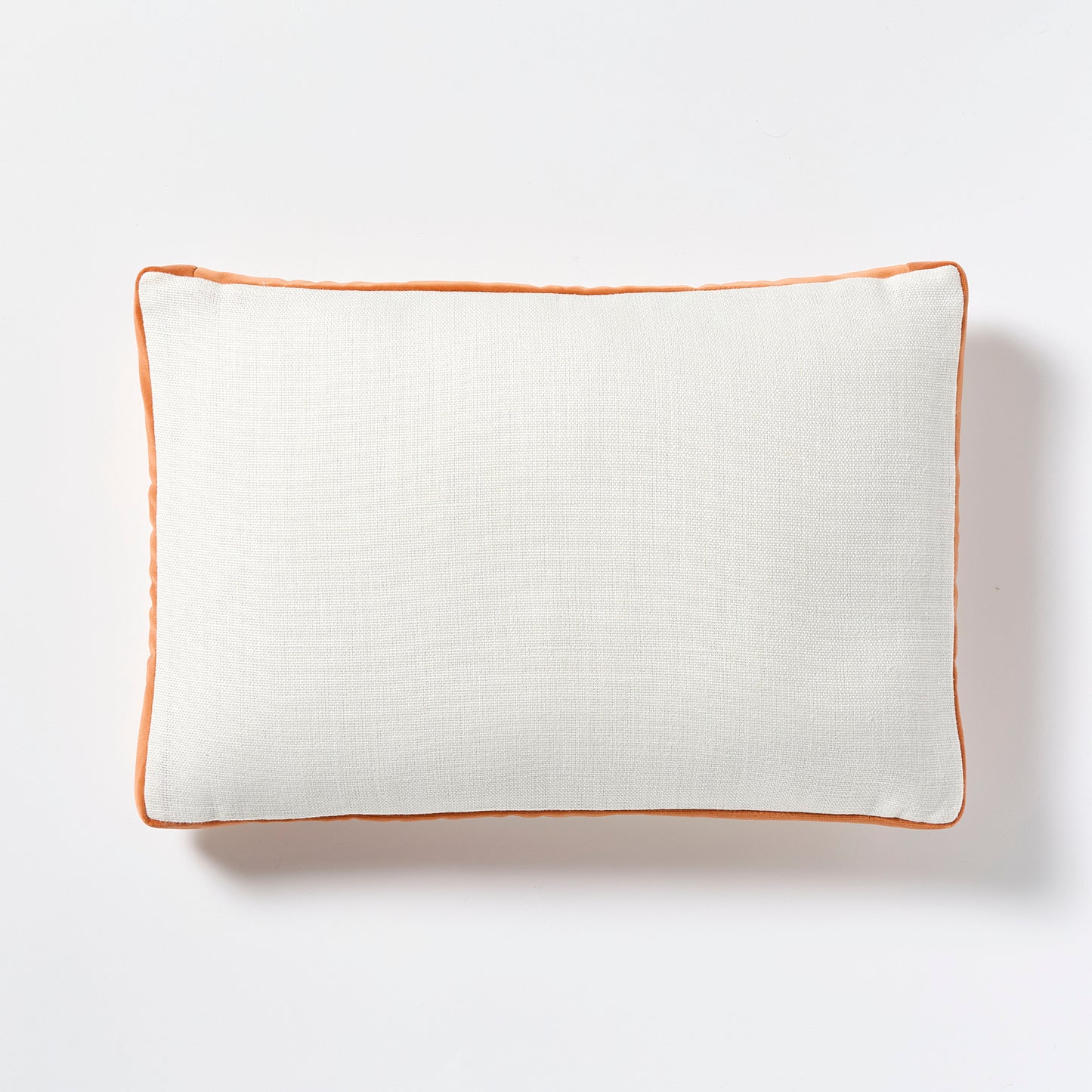 White linen lumbar pillow with pumpkin orange velvet gusset, 20x14 inches.