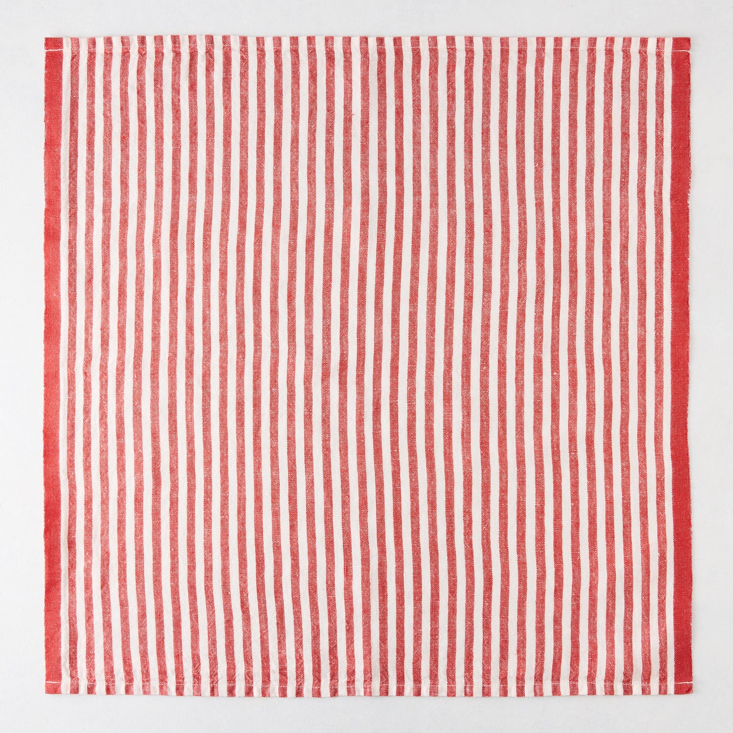 Red ticking stripe linen napkin, 21" square, with thin red and white stripes and a thicker red border.