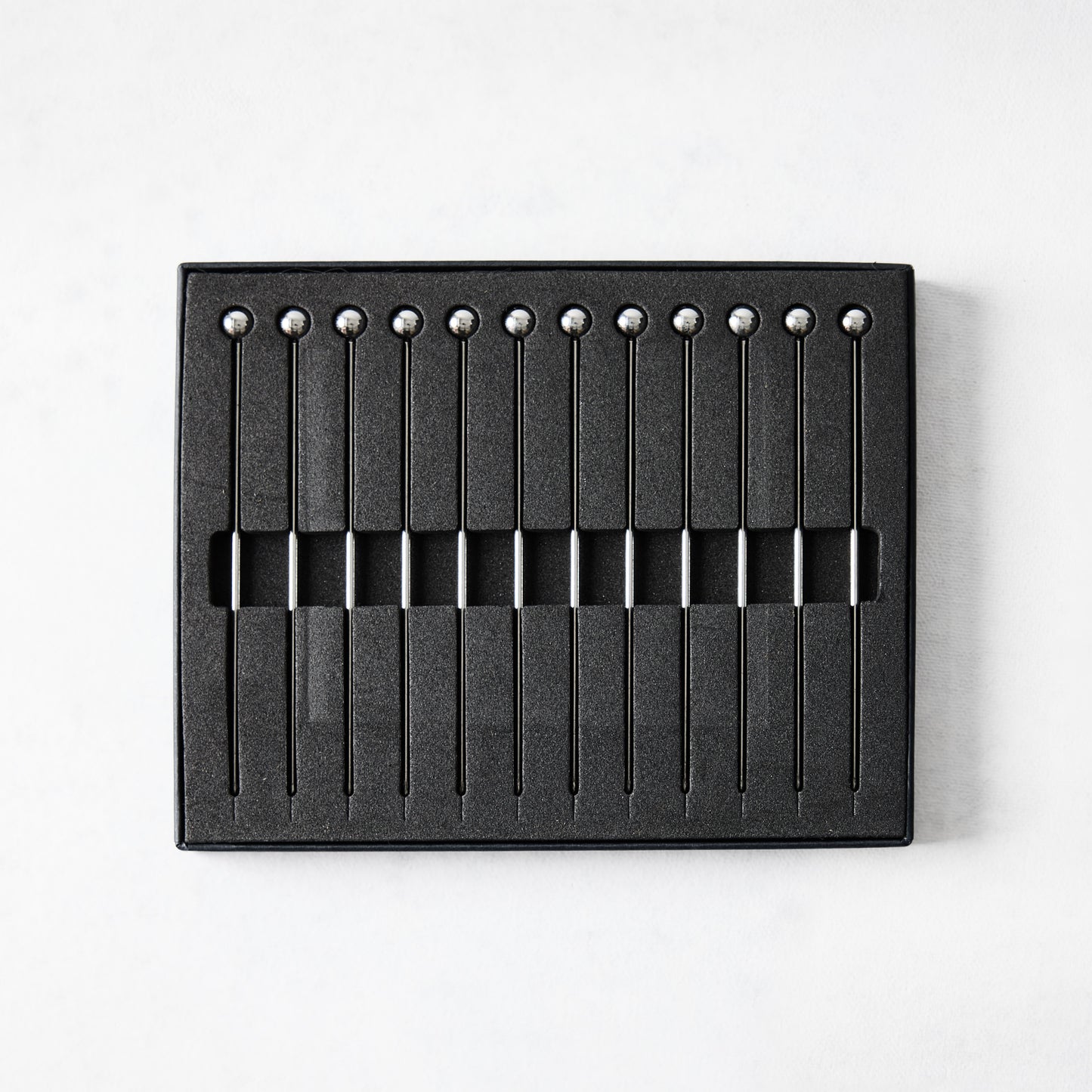 Set of 12 short 4" stainless steel cocktail picks with ball tops, displayed in a black box.