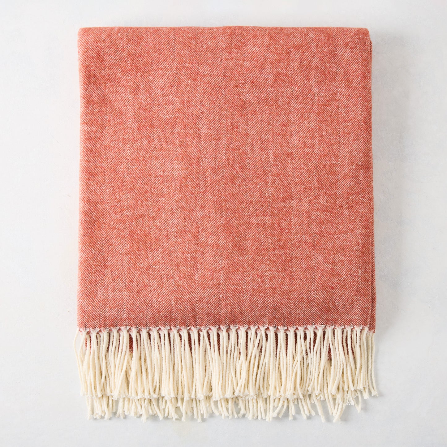 Spice Orange Italian Herringbone Throw Blanket, folded, with cream fringe.