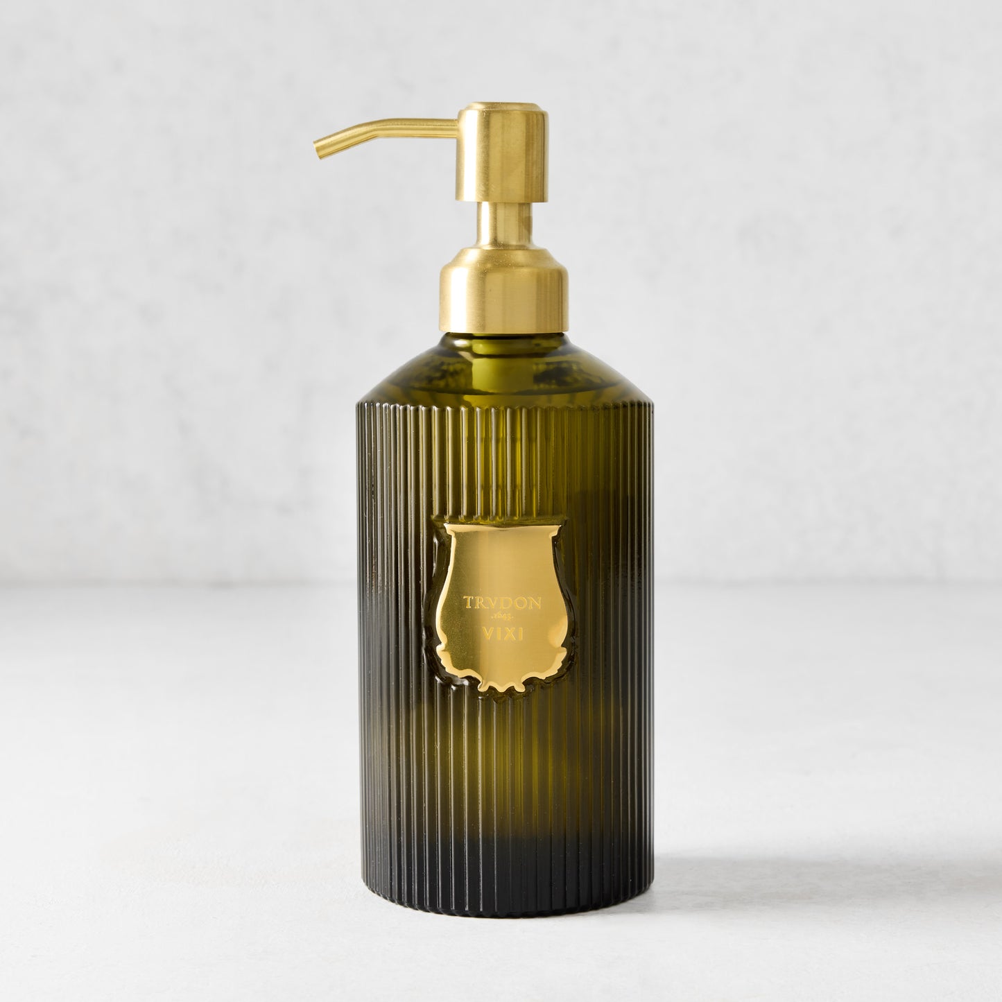 Trudon Vixi 350ml liquid hand soap in a ribbed dark green glass bottle with a gold pump and label.