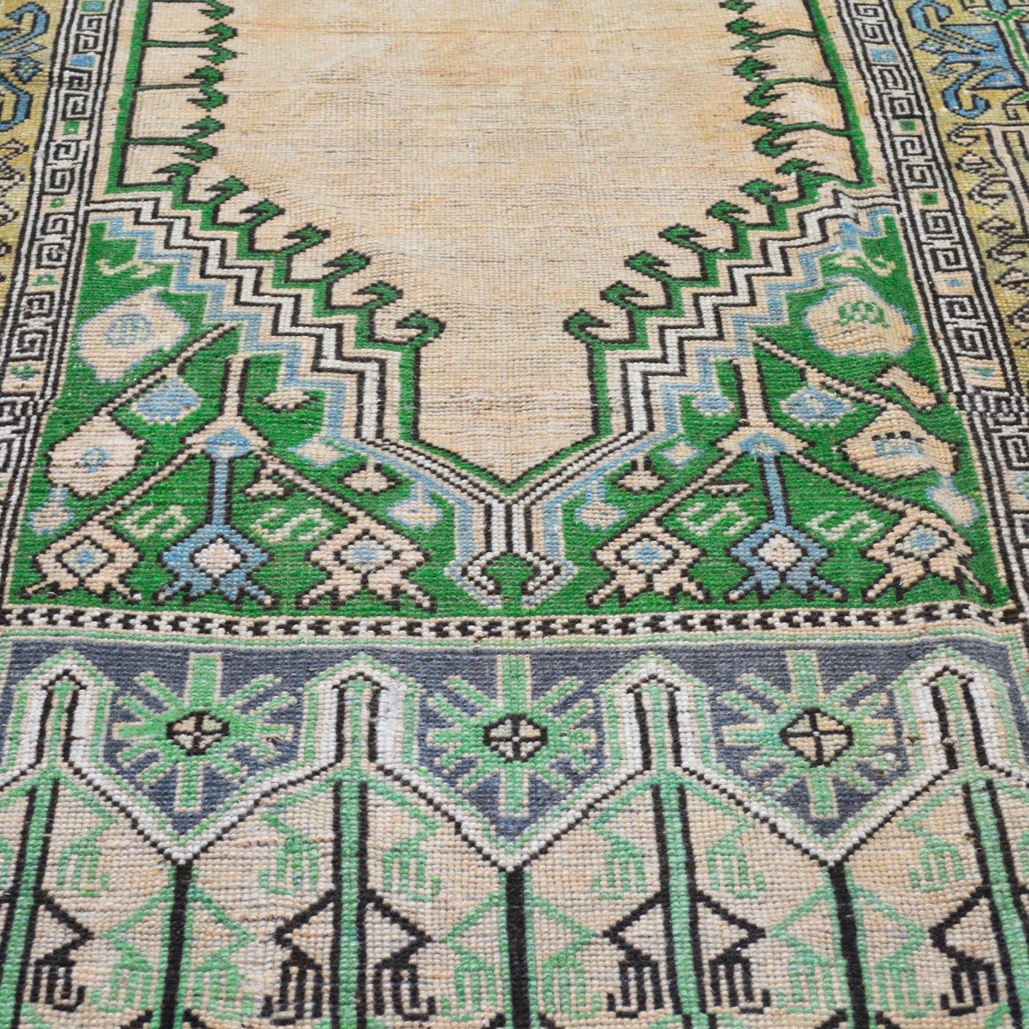 Vintage cream, green, and blue Turkish wool rug, 4'7"x9', with intricate geometric patterns and blue border.