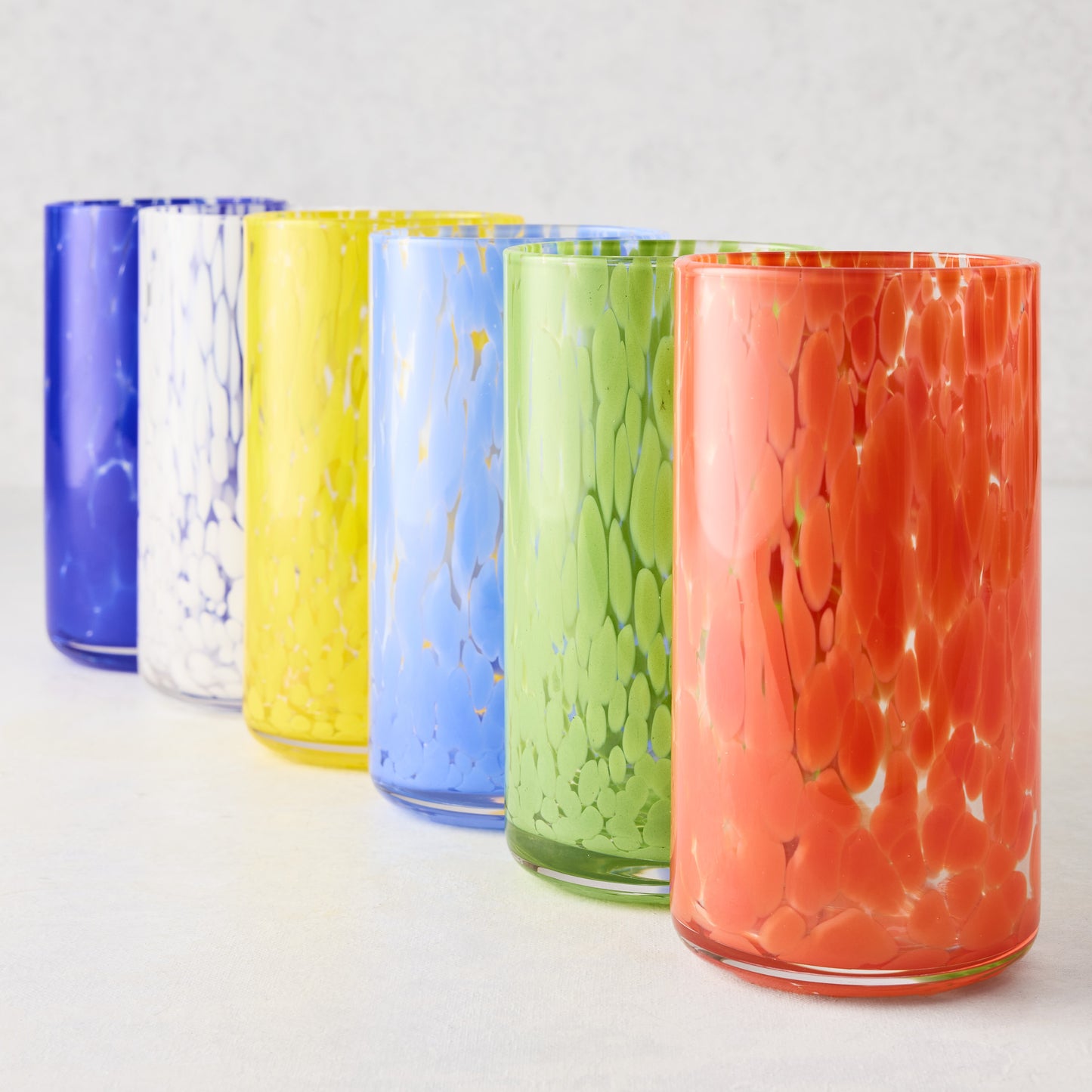 Six spotted highball glasses in blue, white, yellow, light blue, green, and orange.