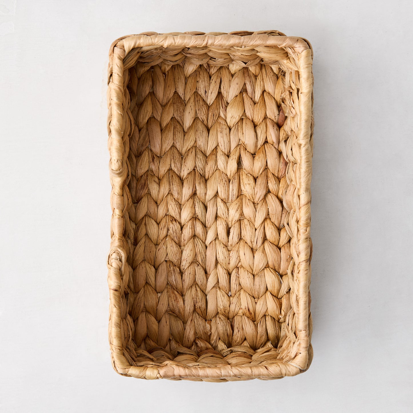Woven hyacinth hand towel holder, rectangular, natural light brown, tightly woven texture.