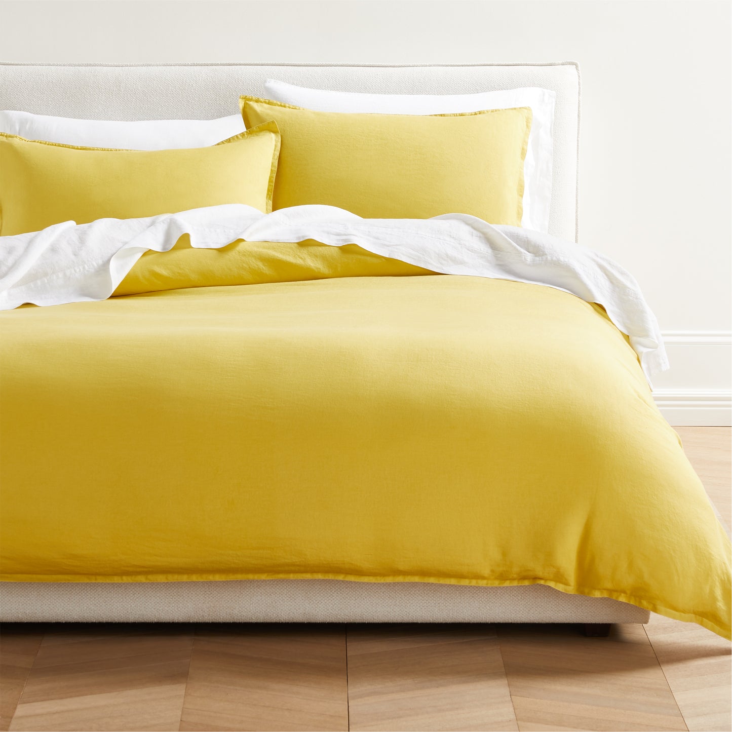 Yellow Washed Linen King Duvet Cover and two shams on a bed with white sheets.