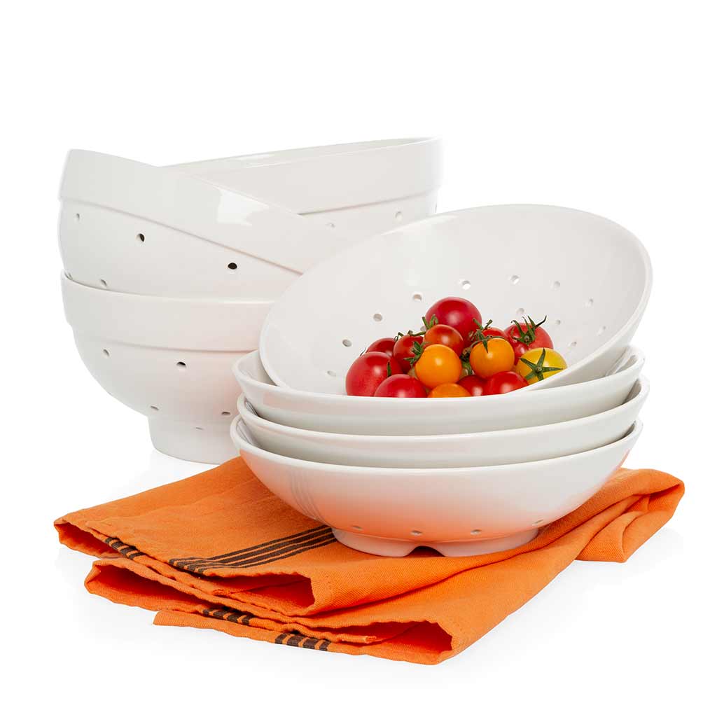 White ceramic Berry Bowl and Colander Gift Set, with a bowl full of cherry tomatoes, on an orange napkin.