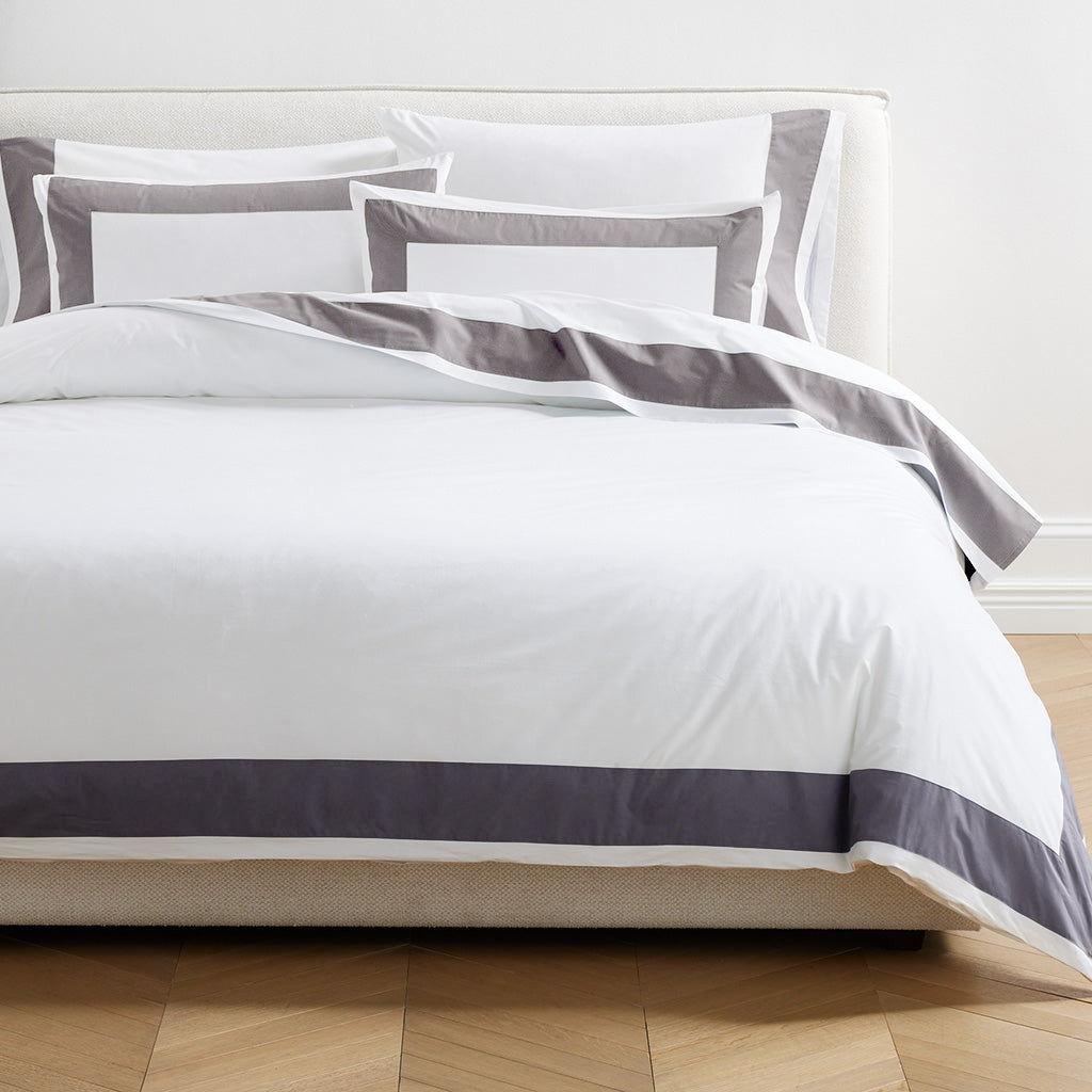 Dark Grey Wide-Band Percale Pillowcases, set of 2, with matching duvet cover on a bed.