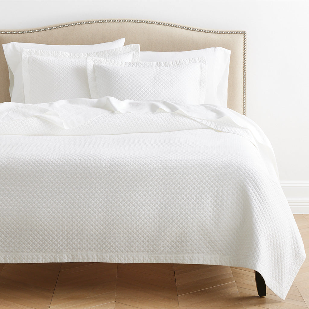 Diamond White Cotton Matelassé Pillow Shams, set of 2, with subtle diamond pattern on a bed.